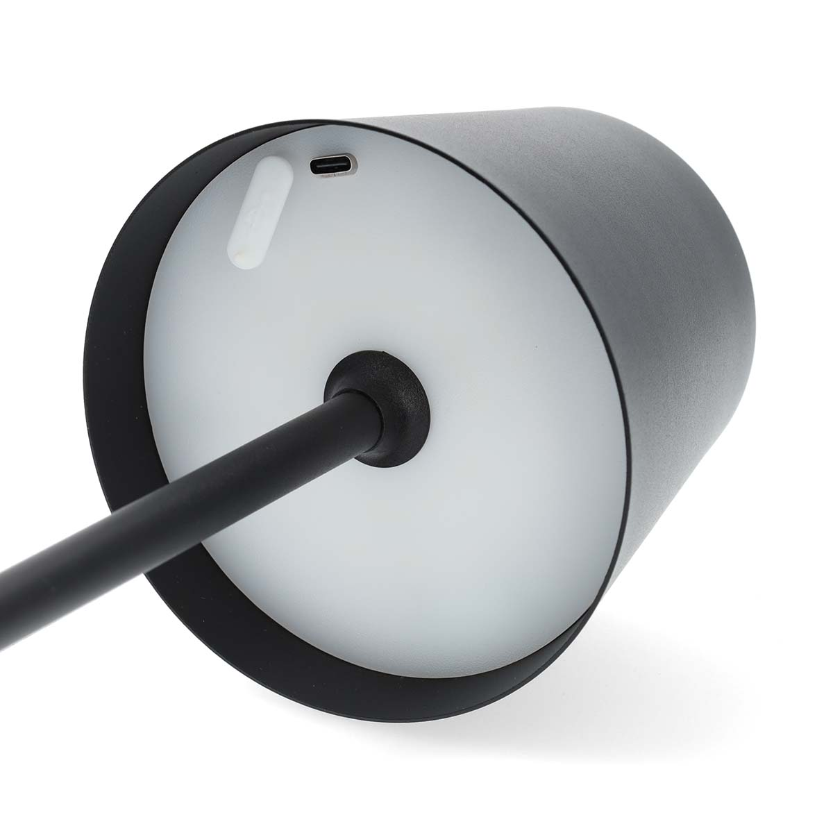 Une lampe noire, vue de dessous, avec une source de lumière blanche et circulaire. Un port de charge est visible.