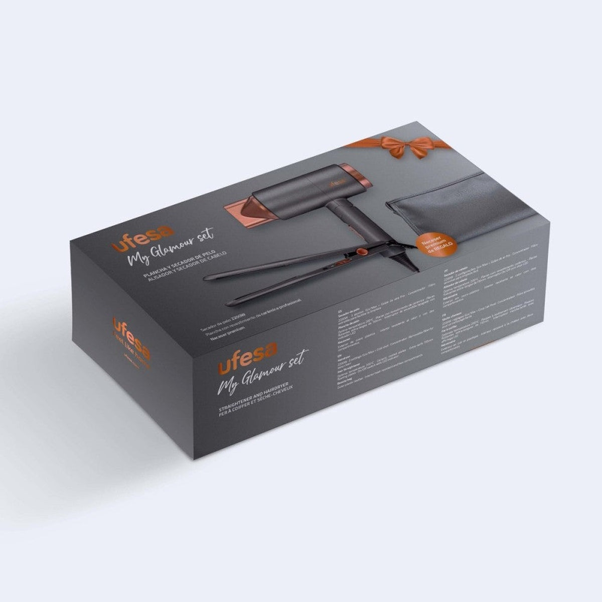 Caja de juego de peinado. Secador y plancha negros. Lazo naranja en la parte superior.
