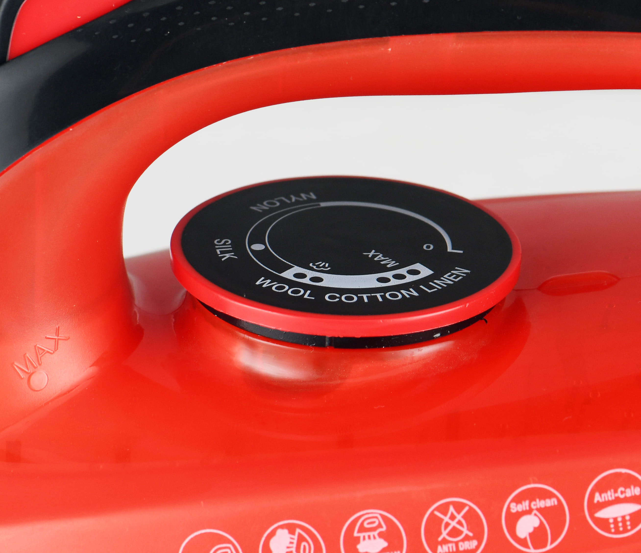 Primo piano di un ferro da stiro rosso con quadrante nero. Il quadrante ha impostazioni per seta, lana, cotone, lino e nylon.