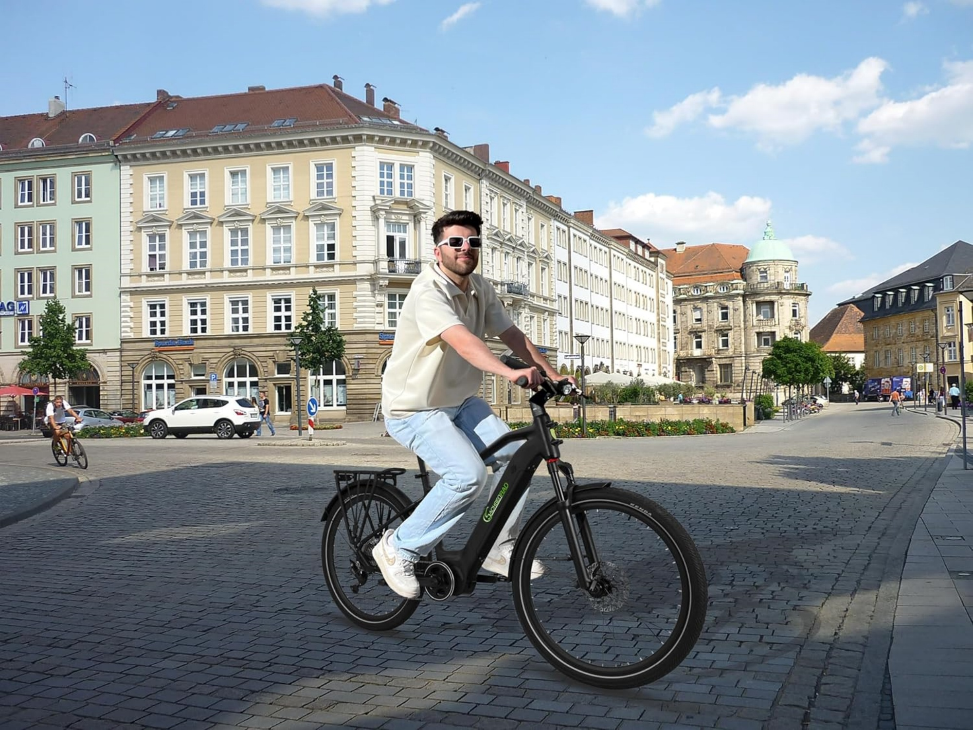 Mann fährt mit einem schwarzen Elektrofahrrad auf einer Kopfsteinpflasterstraße in einem Stadtplatz.