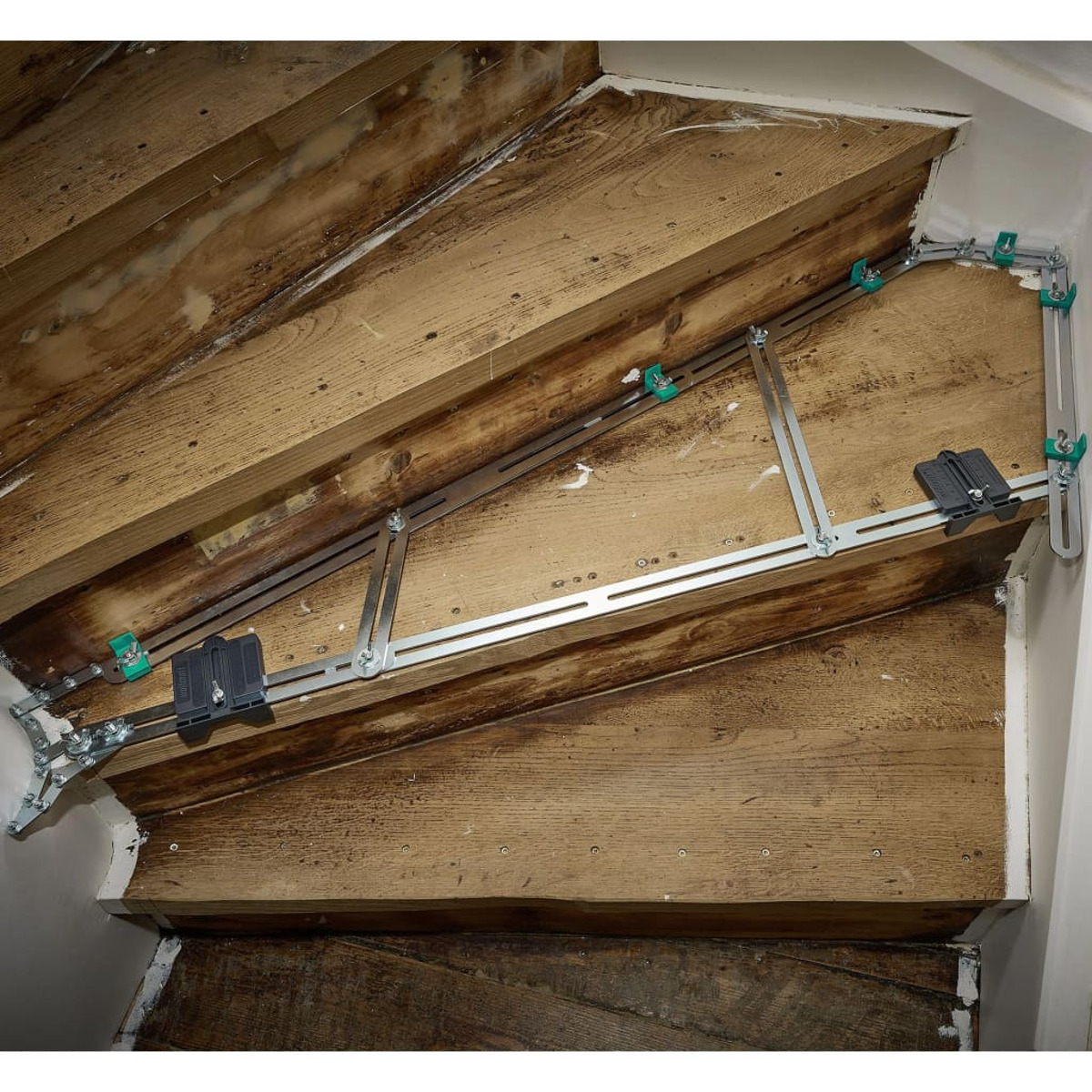 Scala con attrezzi metallici posizionati sui gradini di legno.