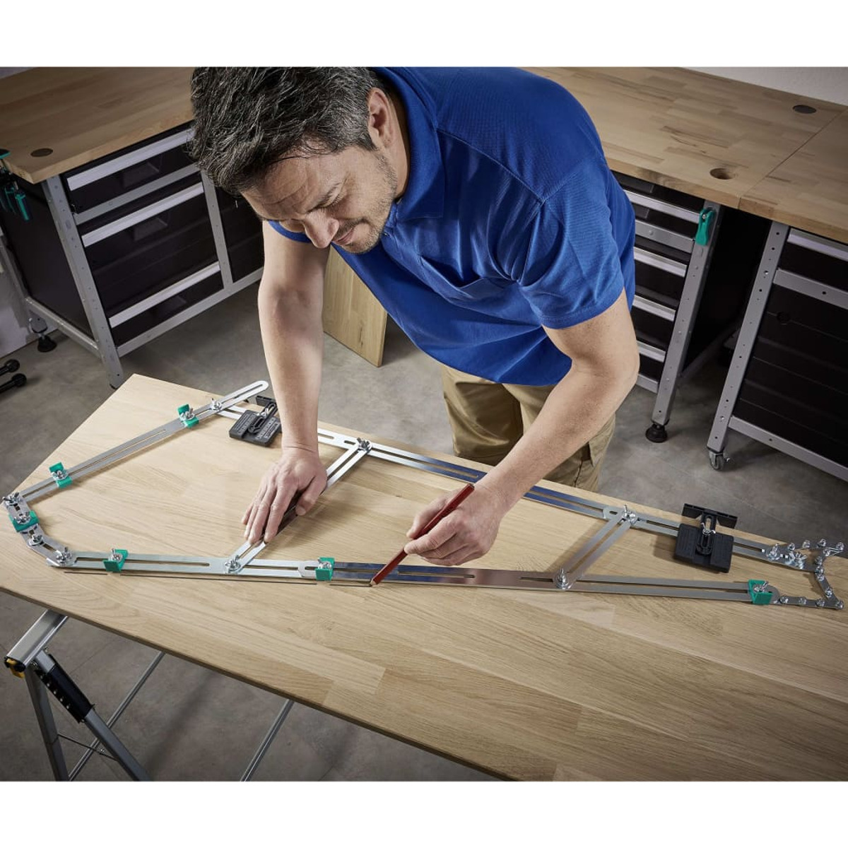 Un uomo che usa uno strumento su una superficie di legno, con altri strumenti e cassetti sullo sfondo.