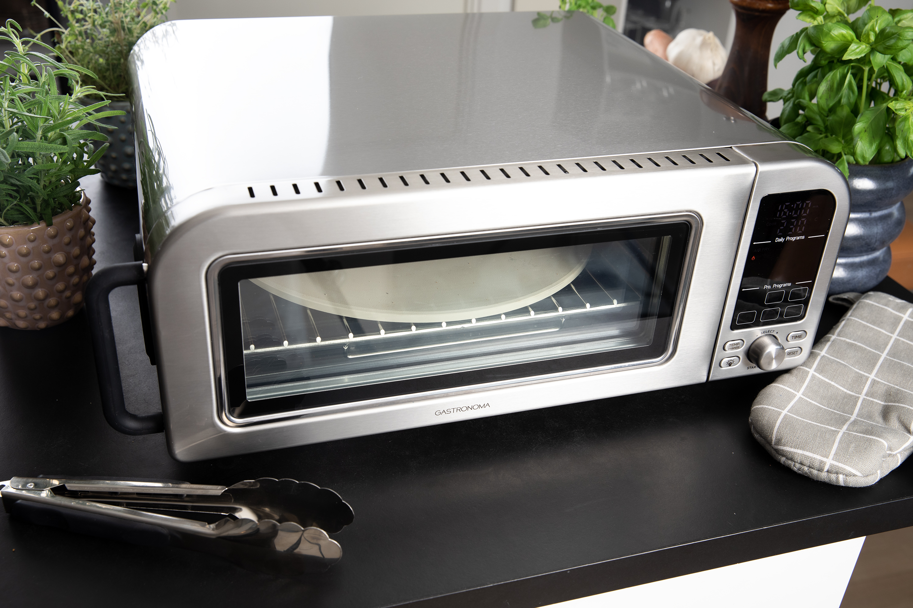 Srebrny piekarnik z drzwiami ze szkła i cyfrowym wyświetlaczem.