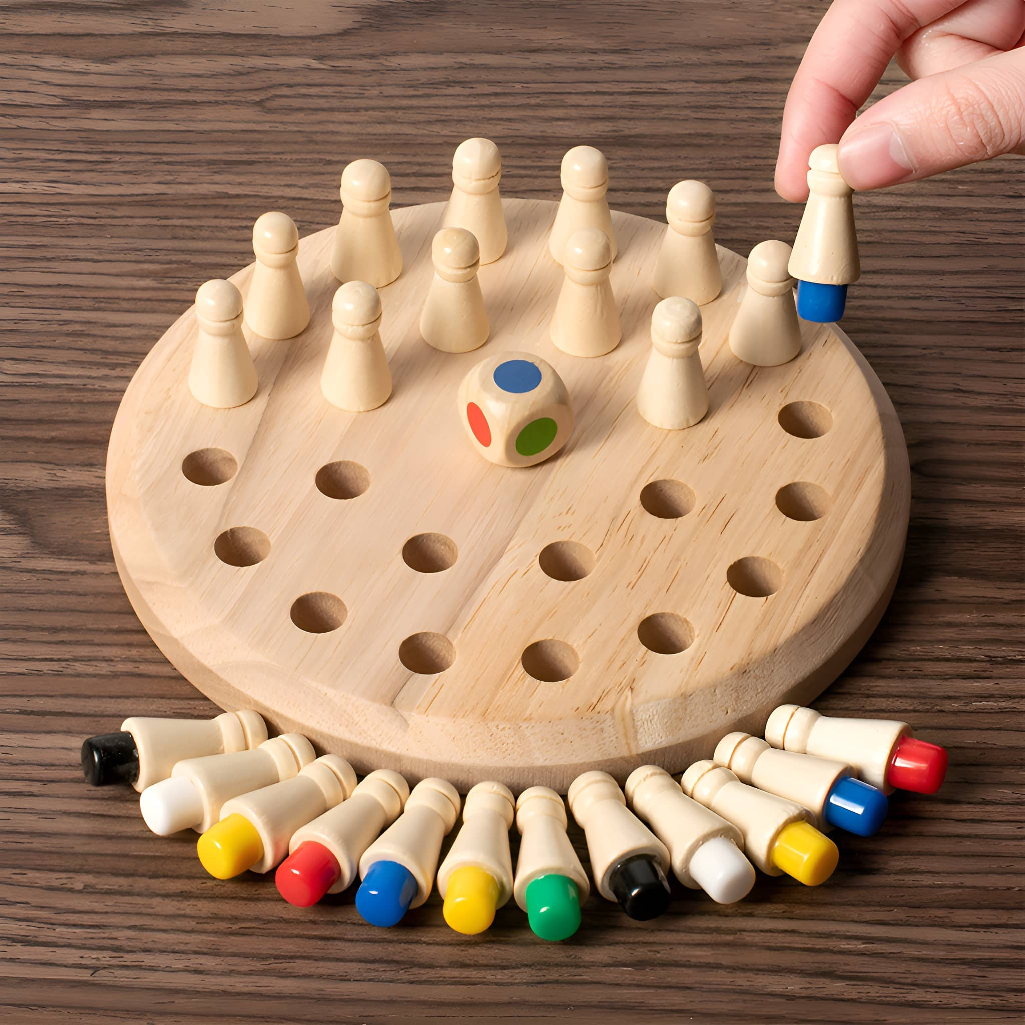 Holzbrettspiel mit Stiften. Hand setzt einen Stift mit blauer Spitze. Andere Stifte sind da.
