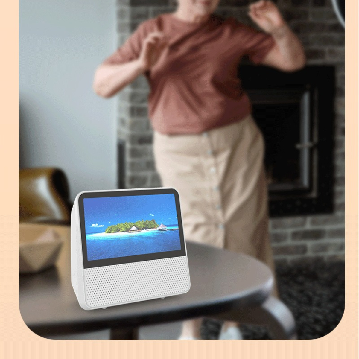 Weißer Smart Speaker mit Bildschirm, der eine Insel zeigt. Frau tanzt im Hintergrund.
