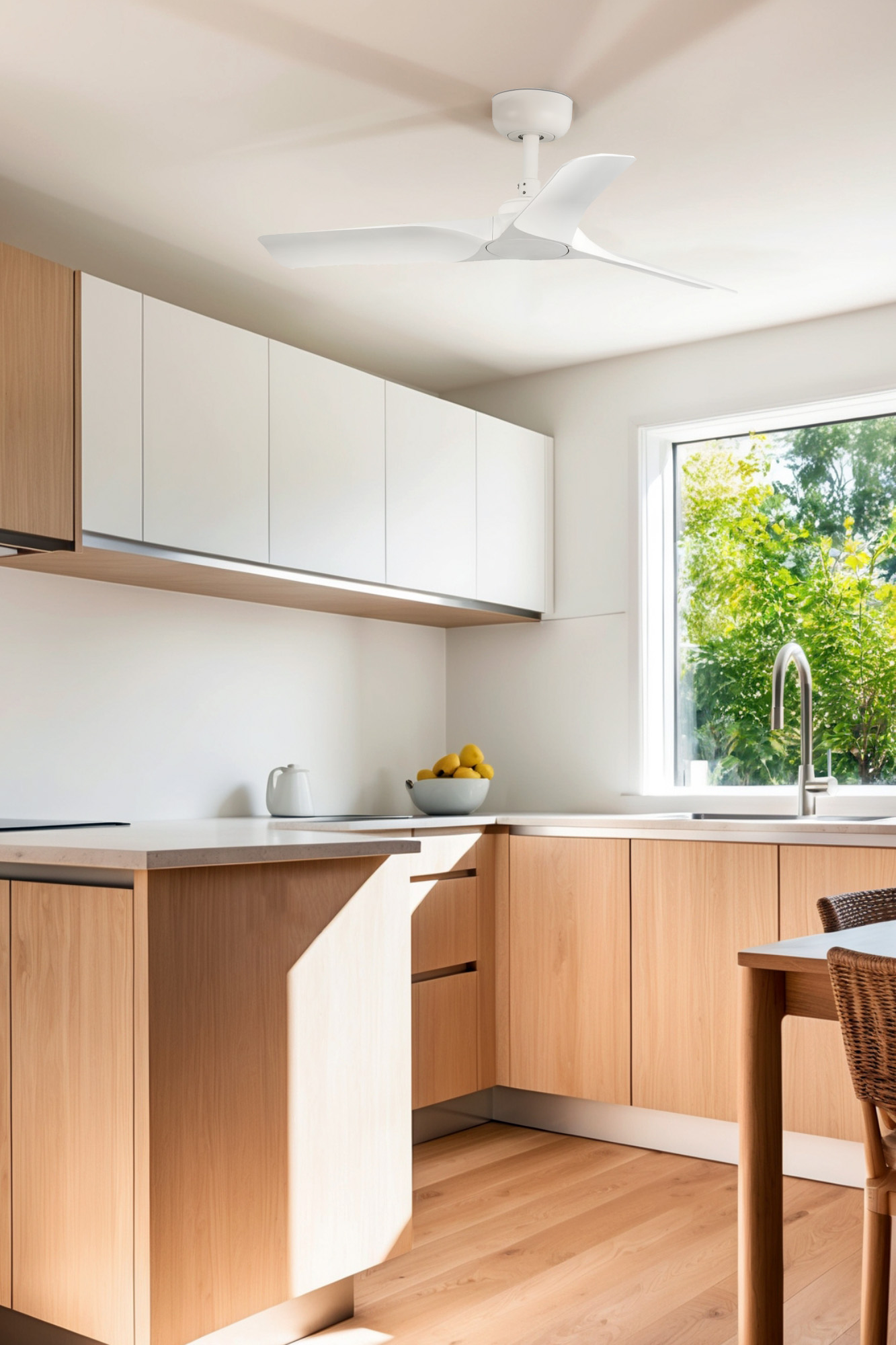Cucina con mobili in legno, piani di lavoro bianchi e ventilatore a soffitto bianco. Luce solare.