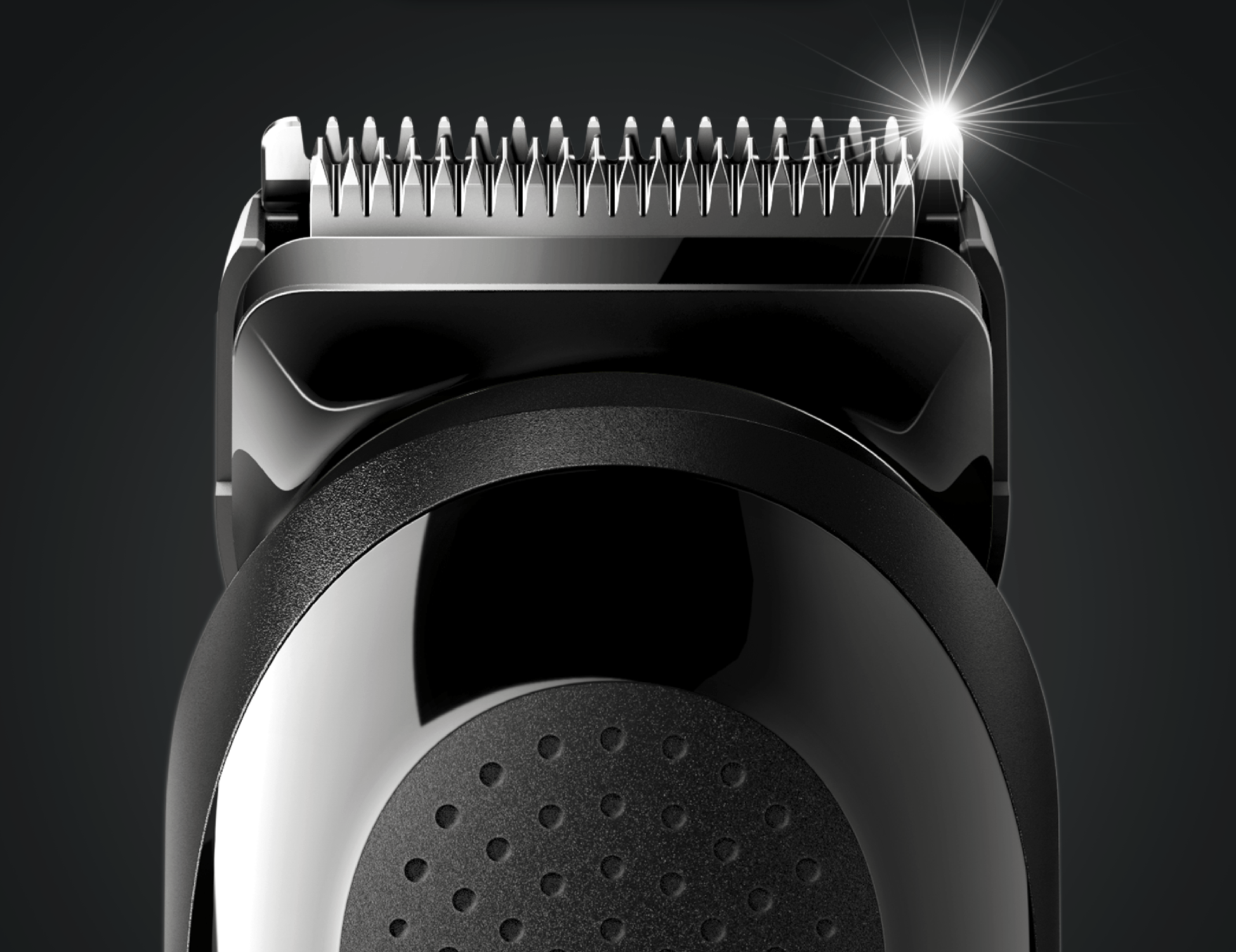 Close-up of a black hair trimmer with shiny blades. The trimmer's body has a smooth, rounded design.