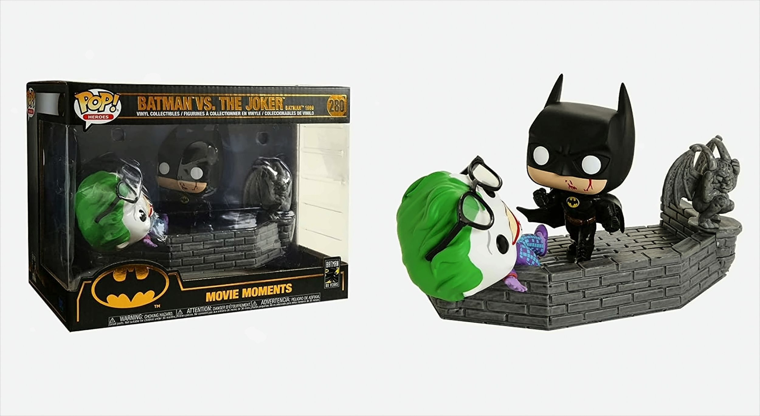 Batman vs. The Joker-Figuren in einer Box und außerhalb auf einem Ziegelsockel.