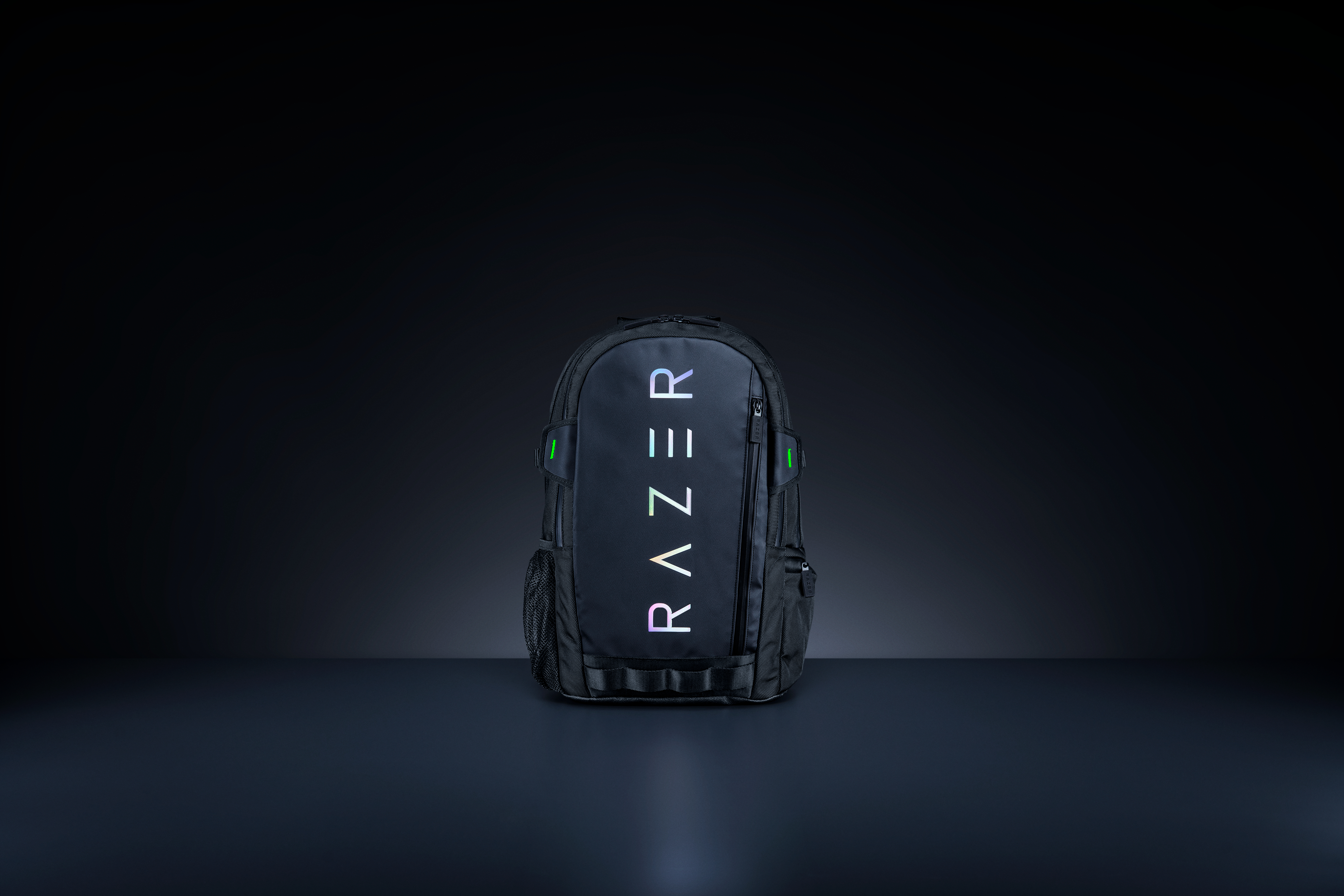 Black backpack with 'RAZER' in white and a dark background. The backpack is on a reflective surface.