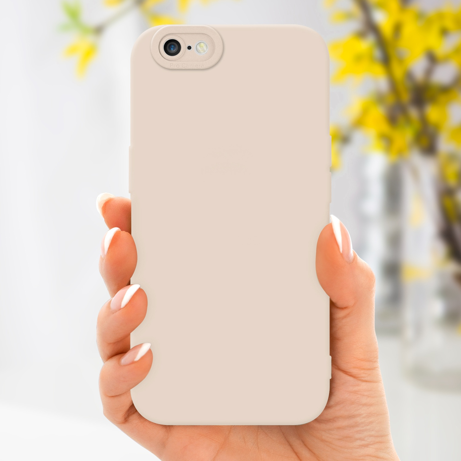 Una mano che tiene una custodia per telefono con un'area fotocamera, e lo sfondo sono fiori sfocati.