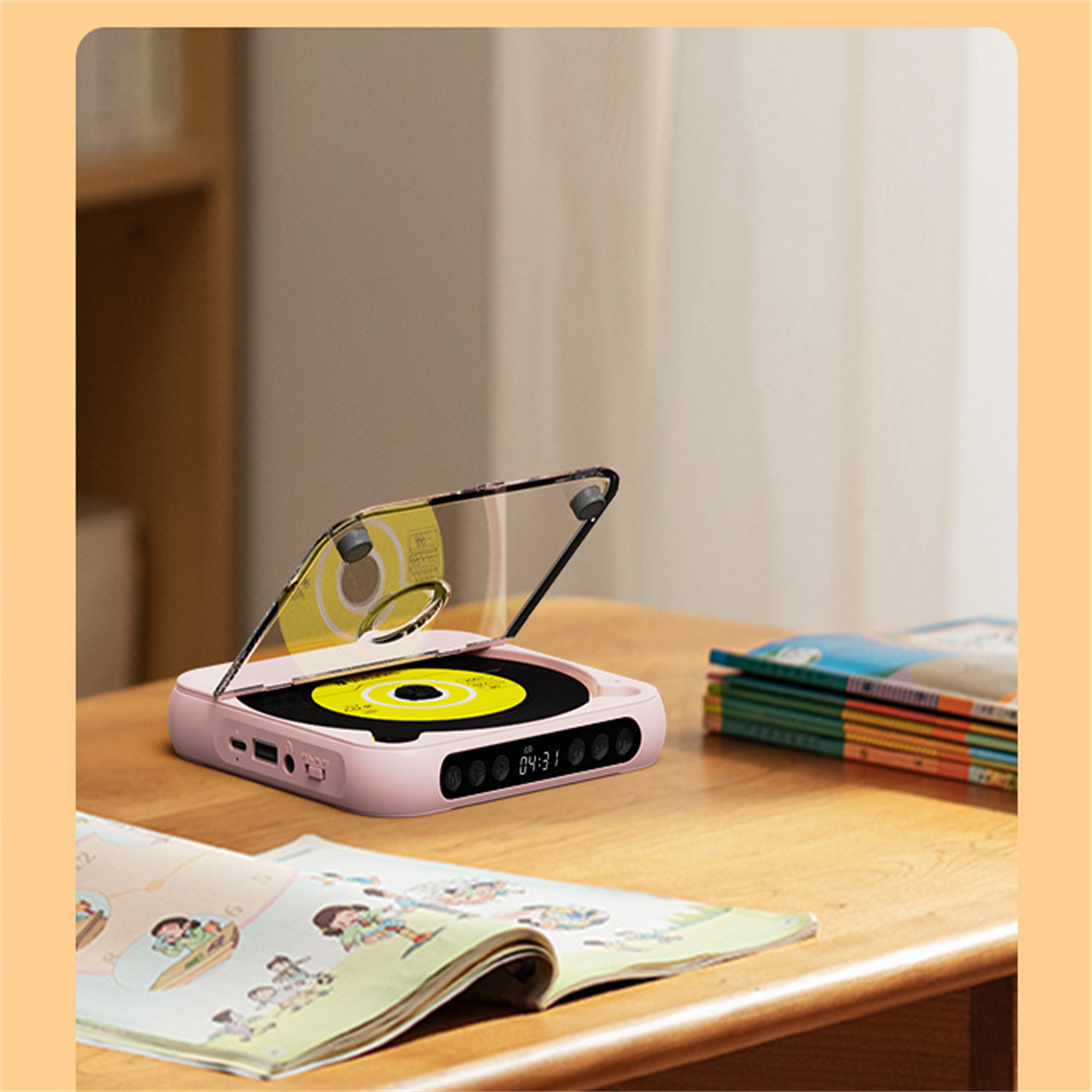 Rosa tragbarer CD-Player auf einem Holztisch mit einem Buch und einer Zeitschrift.