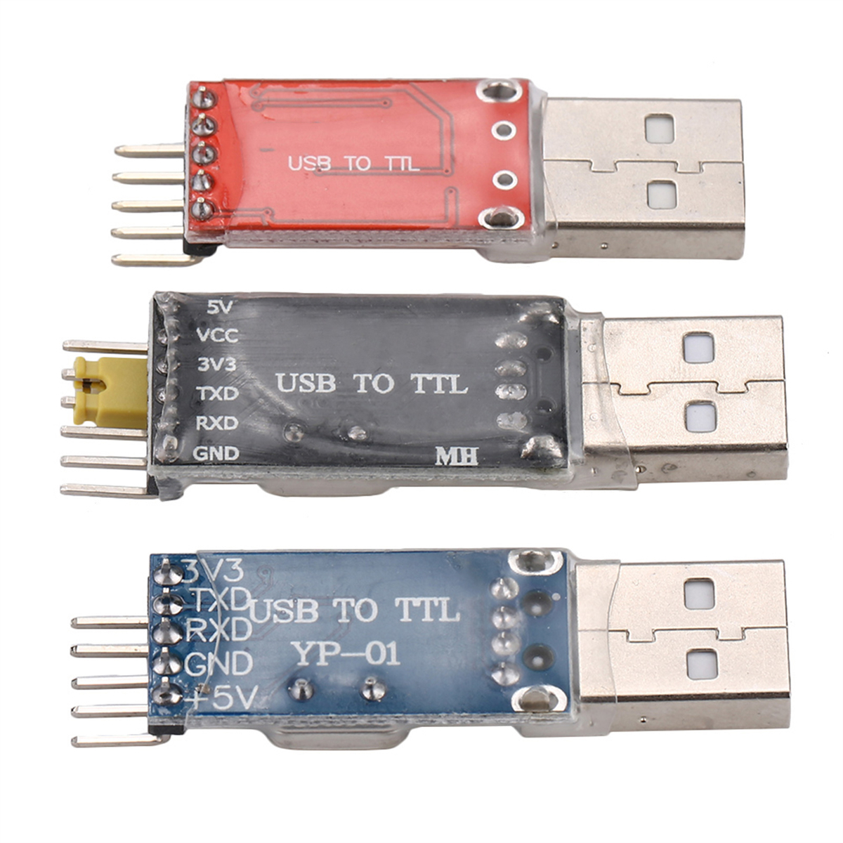 Drei USB-zu-TTL-Module in verschiedenen Farben mit beschrifteten Pins.