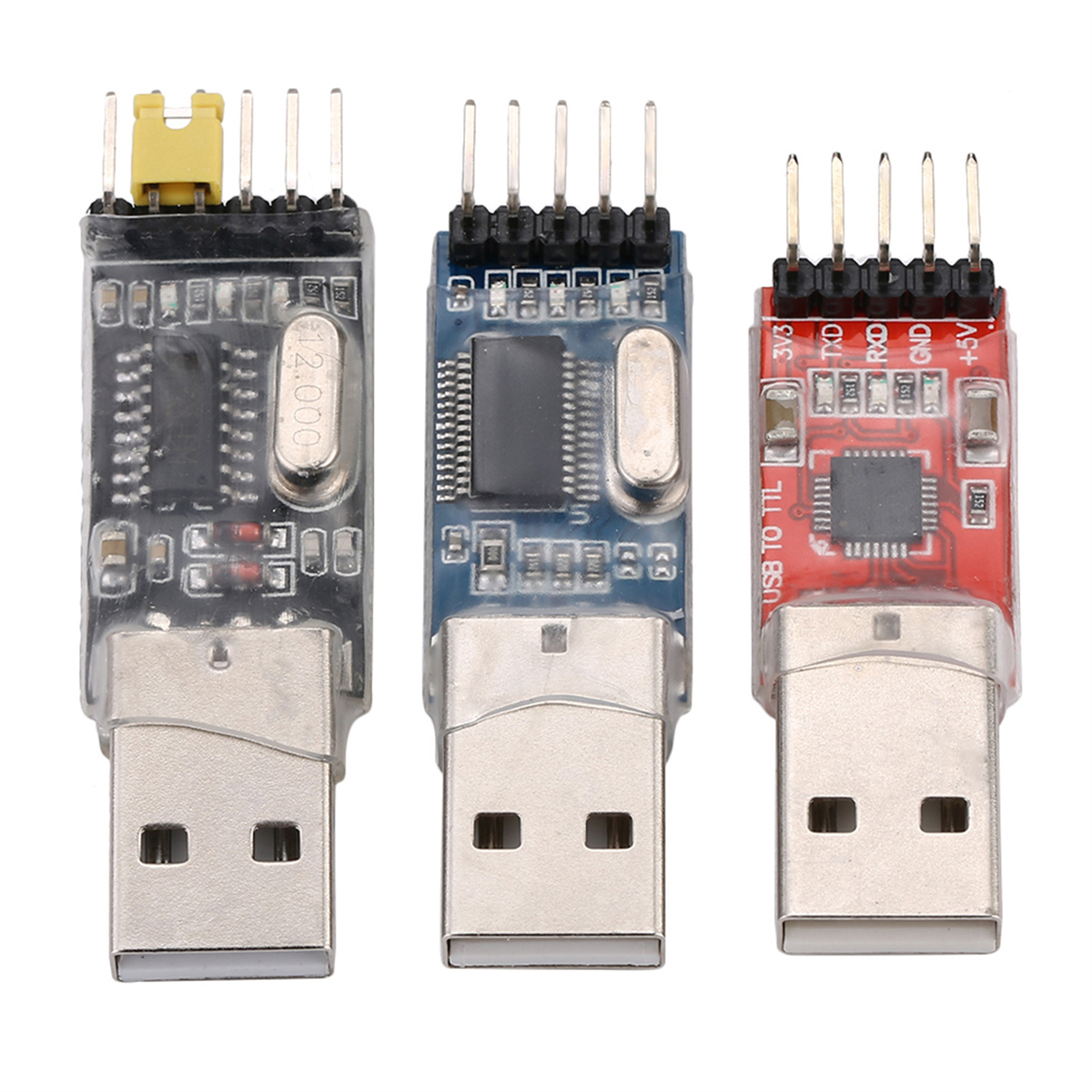 Drei USB-zu-TTL-Konverter: klar, blau und rot, jeweils mit unterschiedlichen Komponenten und Pins.