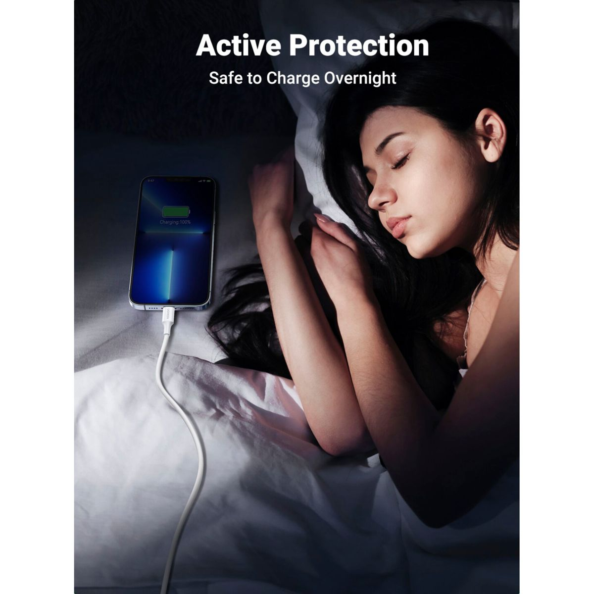 Śpiąca kobieta w łóżku z telefonem ładującym się, pokazującym 100% i kabel.