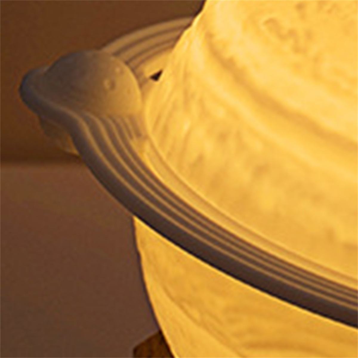 Nahaufnahme einer weißen Planetenlampe mit leuchtendem Licht und Ringdesign.