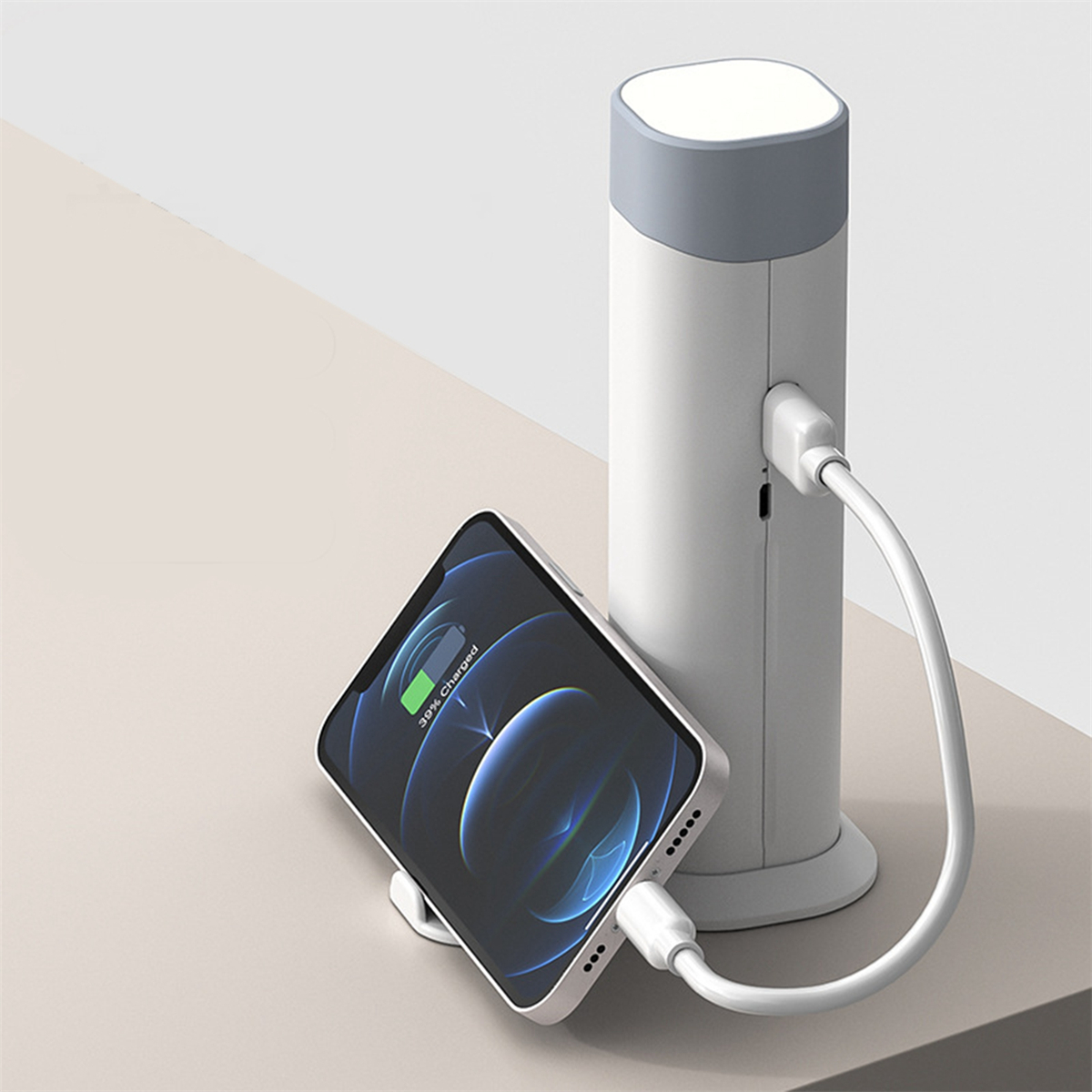 Eine weiß-graue Ladestation mit Telefon, 39% geladen, und Kabel.