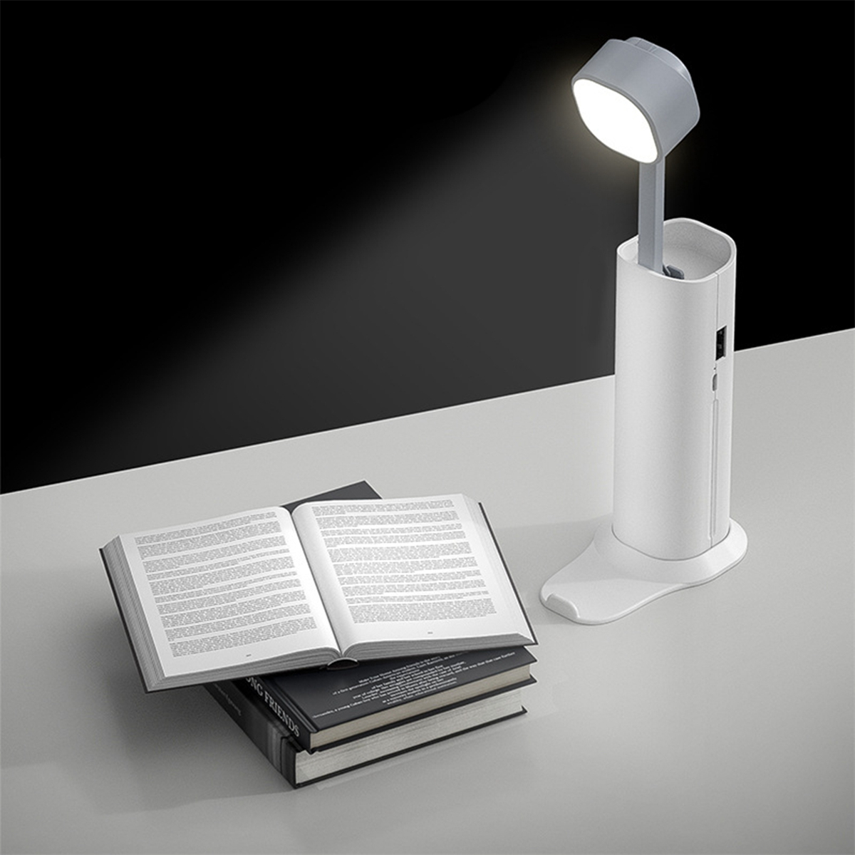 Weiße und graue Schreibtischlampe, beleuchtet, mit Büchern und weißem Hintergrund.
