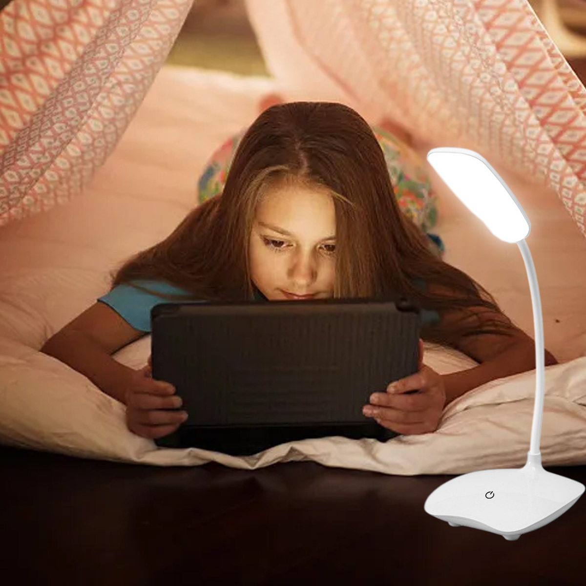 Ein Mädchen liegt mit einem Tablet auf einem Bett, beleuchtet von einer weißen, verstellbaren Schreibtischlampe.