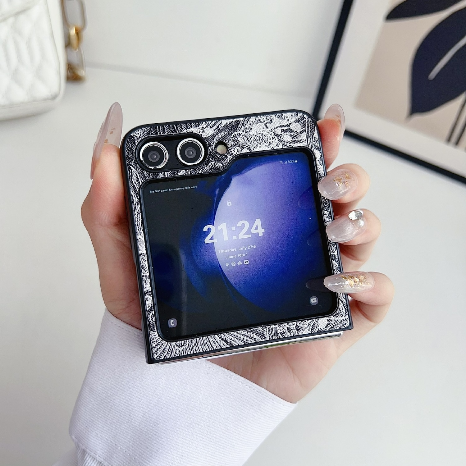 Eine Hand hält eine silberne und schwarze Handyhülle, die ein faltbares Telefon bedeckt.