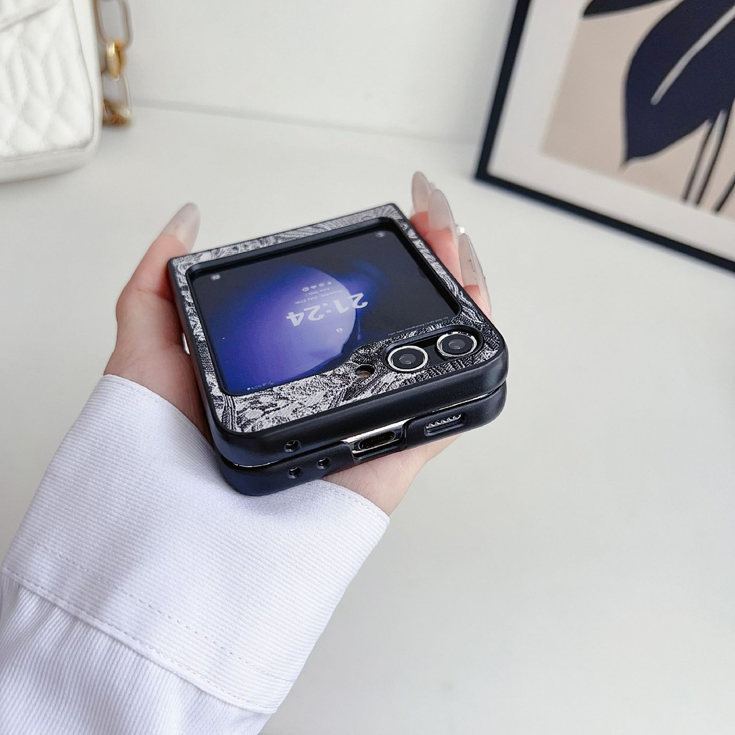 Faltbares Telefon in einer Hülle, in der Hand gehalten, zeigt den Bildschirm des Telefons.