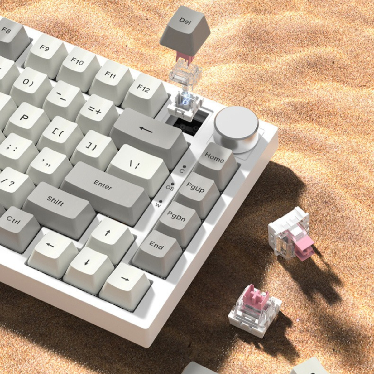 Weiße Tastatur mit grauen Tasten, einem silbernen Drehregler und einer entfernten Taste, die pinke Schalter zeigt.