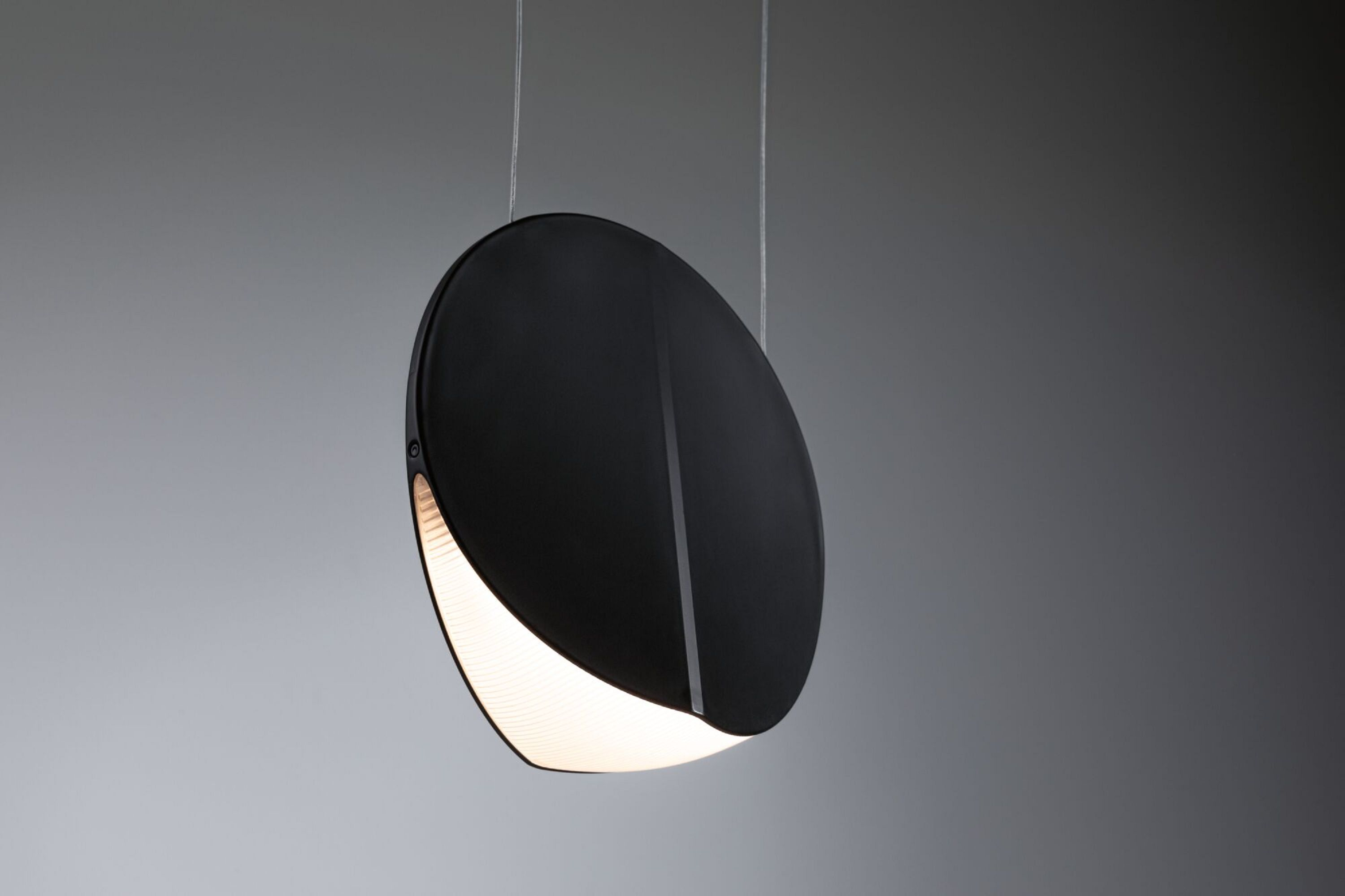 Schwarze moderne Pendelleuchte mit einem gebogenen weißen Lichtstreifen, von oben abgehängt.