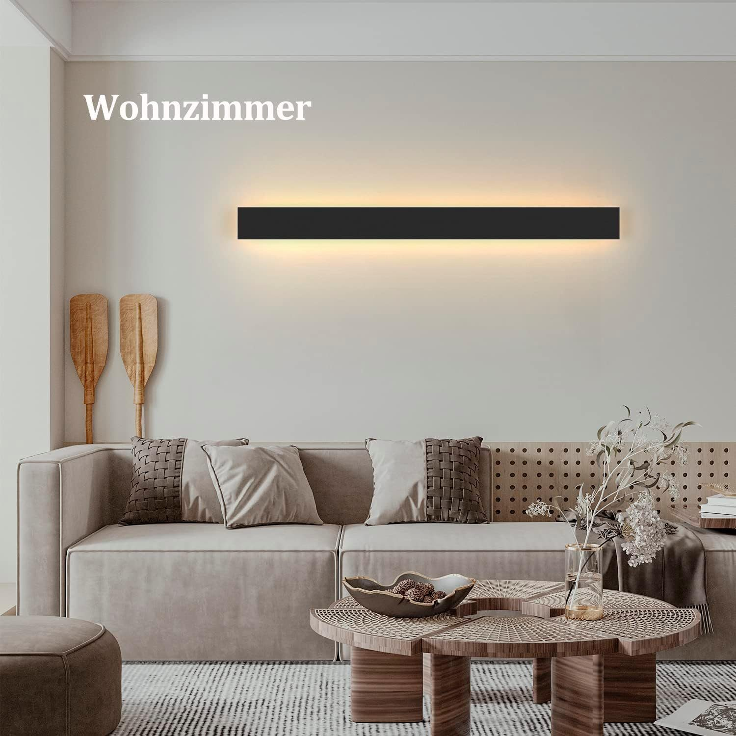 Eine Wohnzimmerszene mit Sofa, Couchtisch und Wandleuchte. Das Wort Wohnzimmer steht oben.