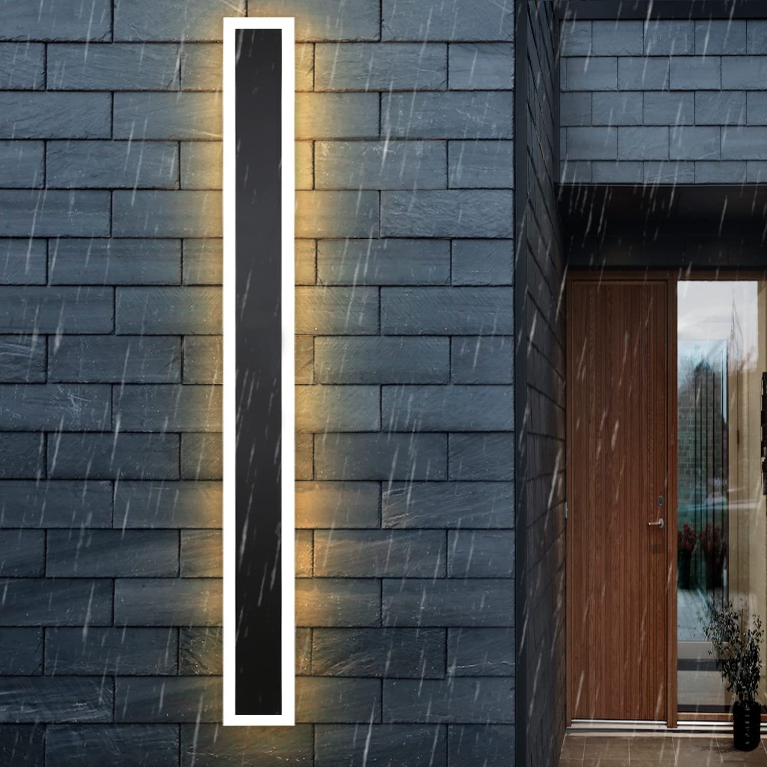 Una luce da parete esterna bianca e nera, illuminata contro un muro di mattoni grigio scuro, con pioggia.