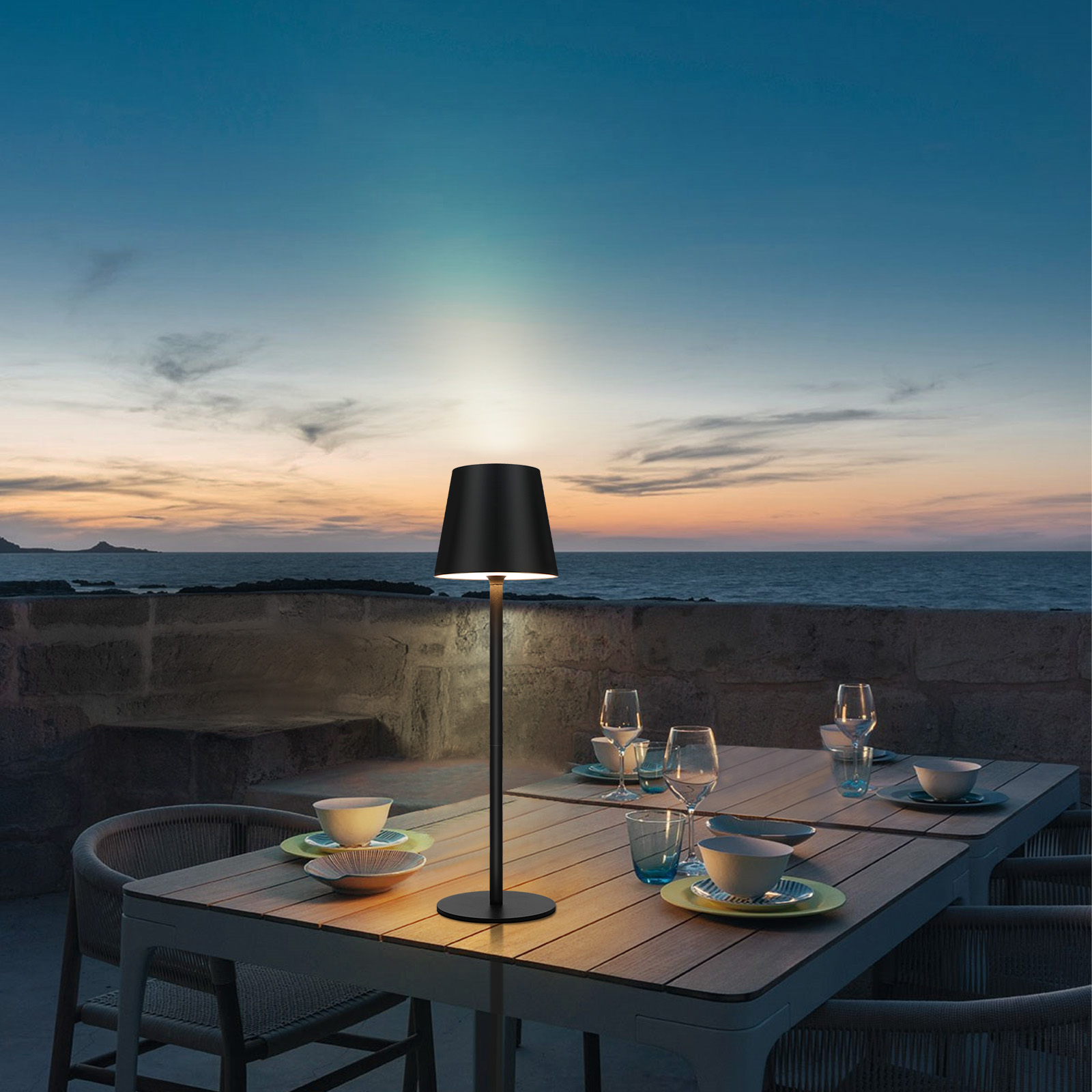 Czarna lampa z czarnym kloszem na stole, otoczenie zewnętrzne.