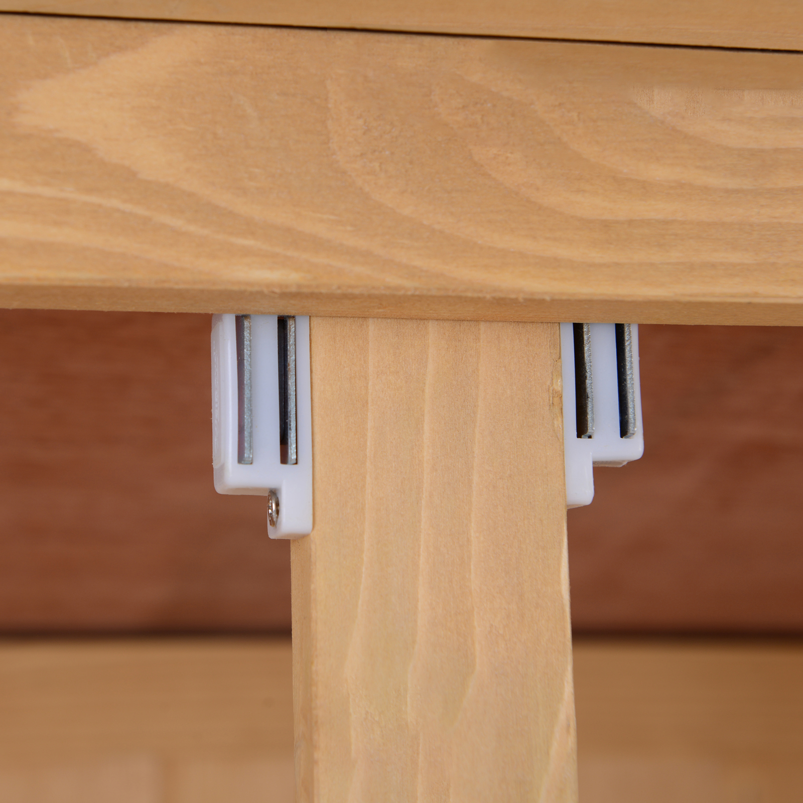 Primo piano del supporto di una struttura in legno. Pezzi di plastica bianca attaccati al legno.