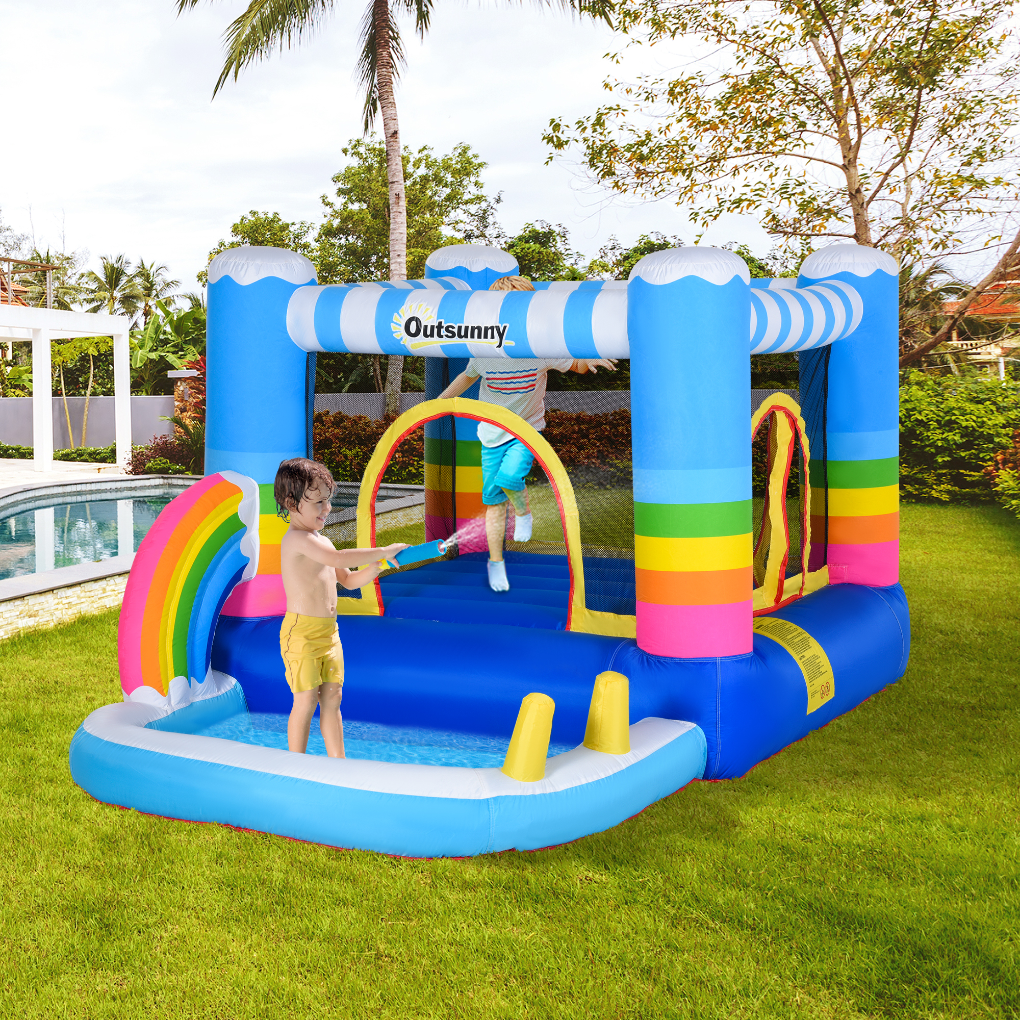 Bambini che giocano in un castello gonfiabile blu con un arcobaleno e giochi d'acqua.