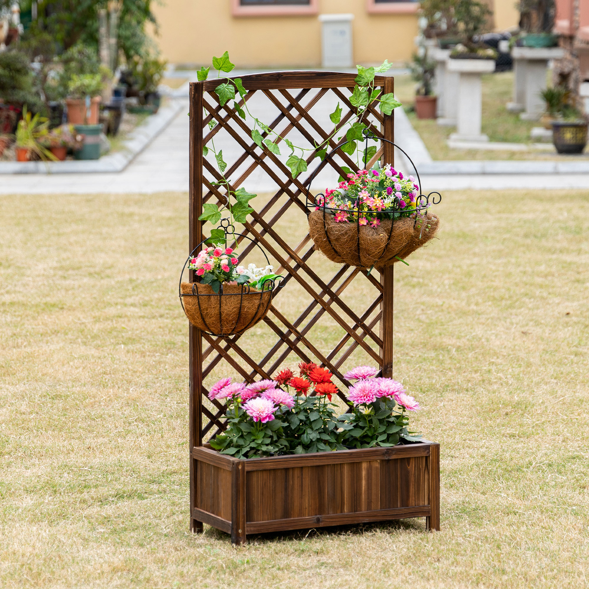 Enrejado de madera con cestas colgantes y flores, en un jardín. Césped en primer plano.