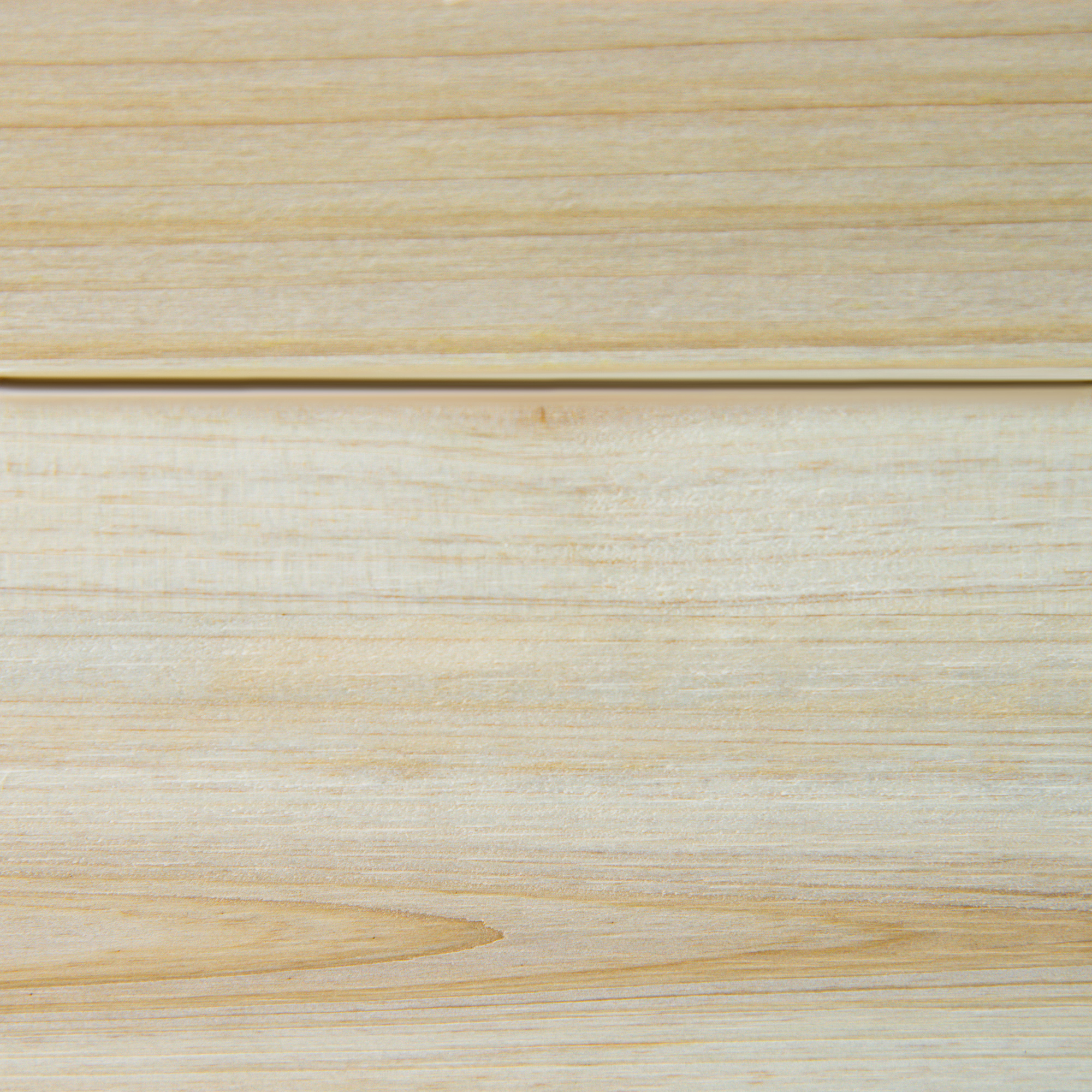 Primo piano di assi di legno, che mostrano le venature. Le assi sono di colore marrone chiaro.