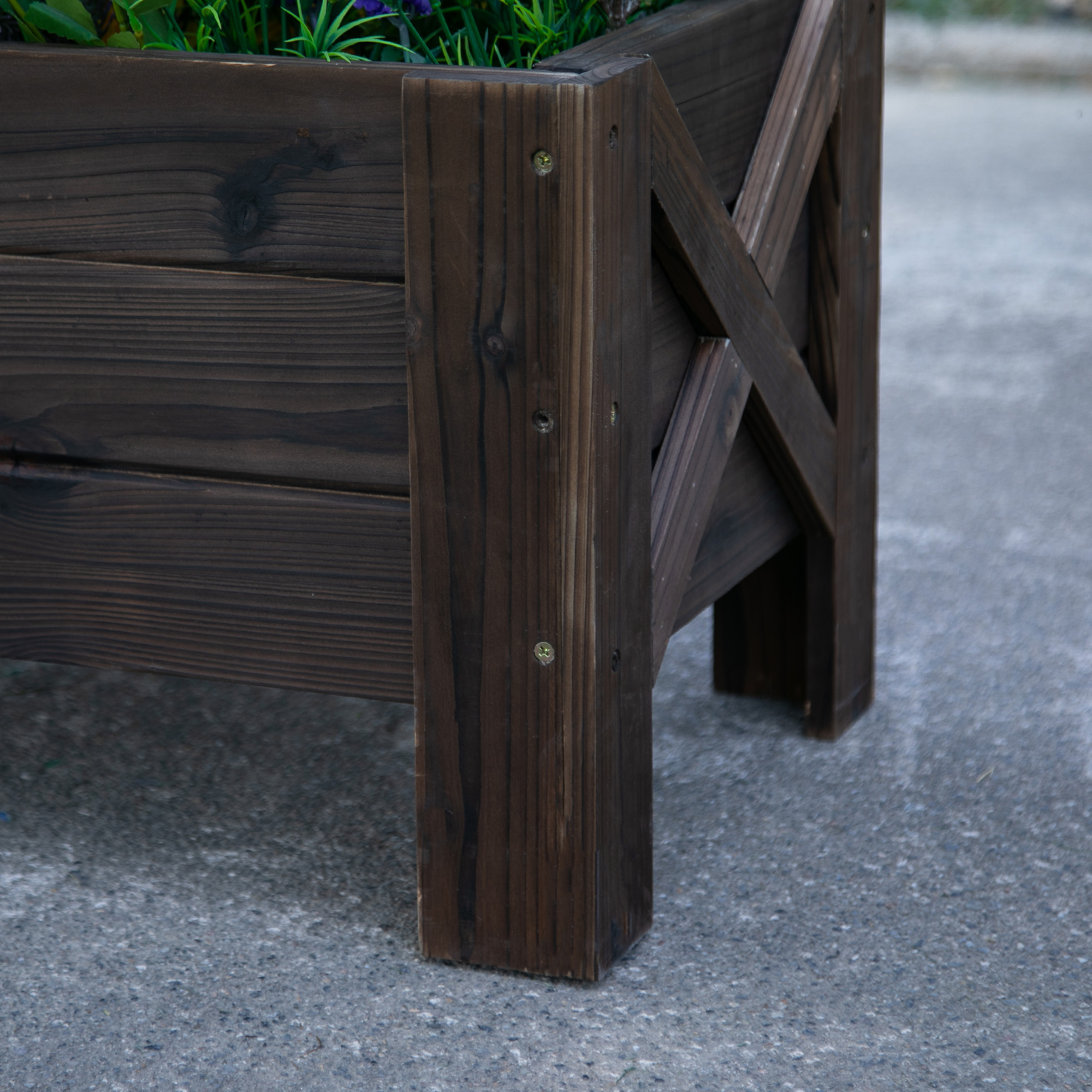 Primo piano di fioriera in legno marrone scuro con fiori.