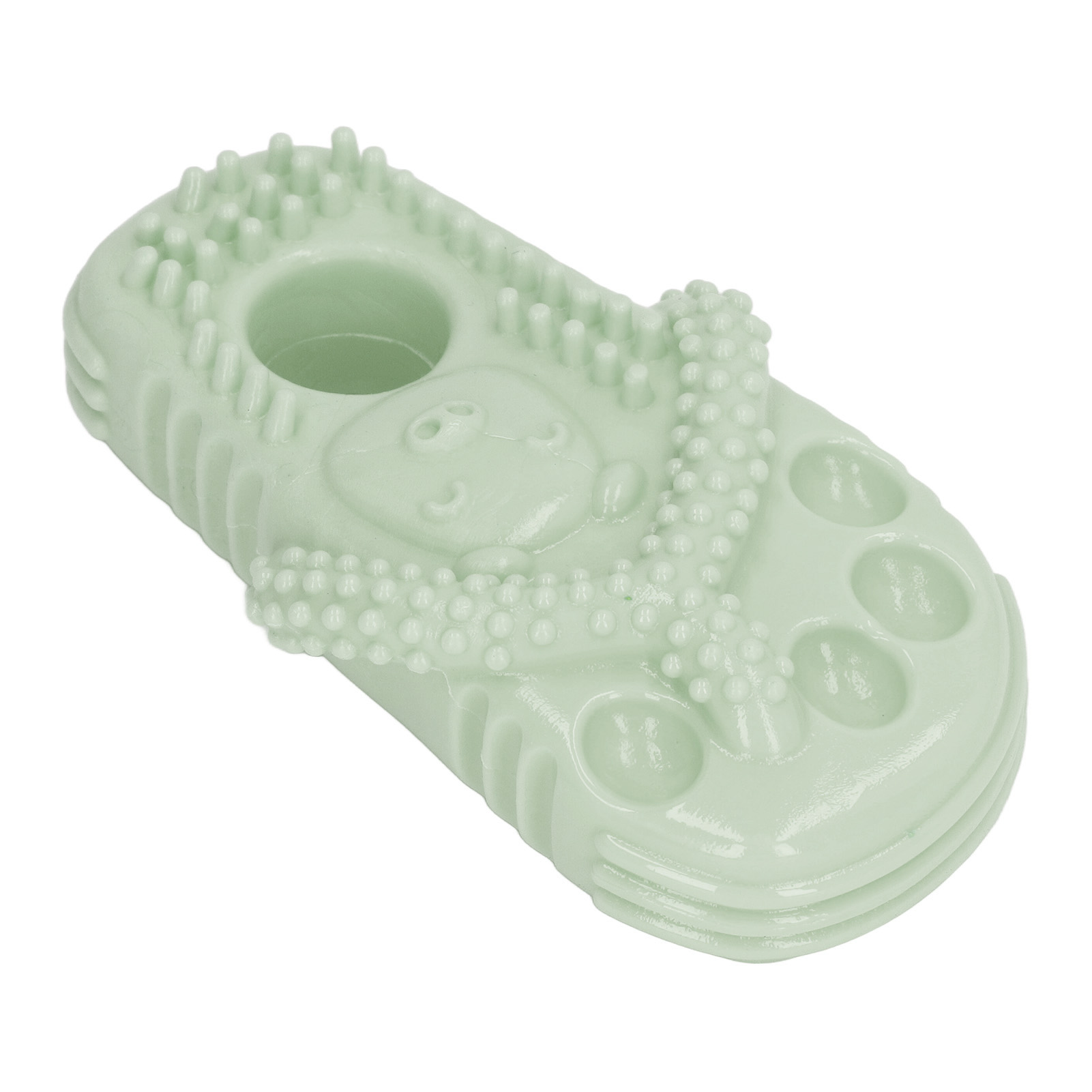 Grünes Hundespielzeug in Sandalenform. Es hat eine strukturierte Oberfläche mit kleinen Erhebungen und Riemen.