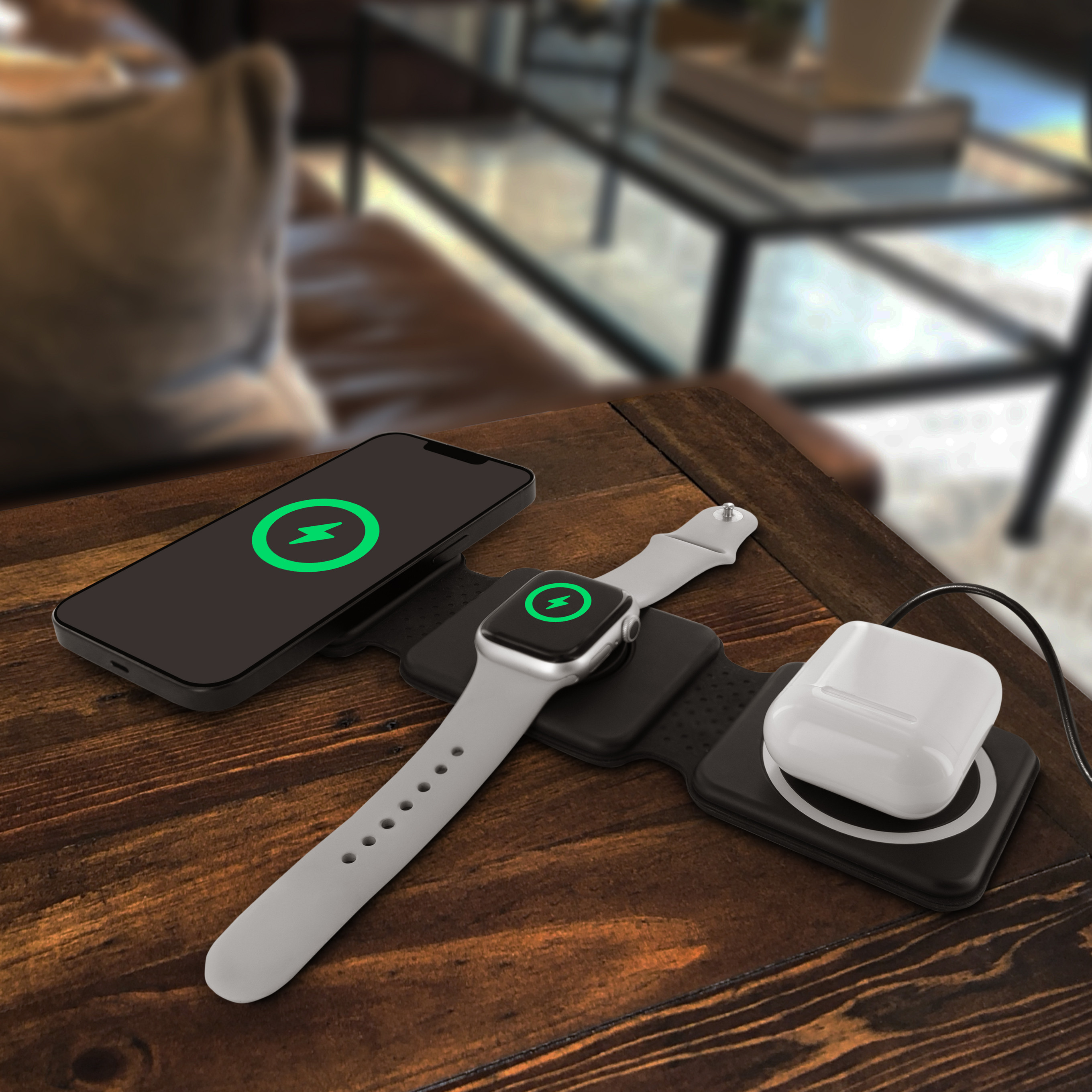 Mesa de madera con teléfono, reloj y auriculares cargando de forma inalámbrica.