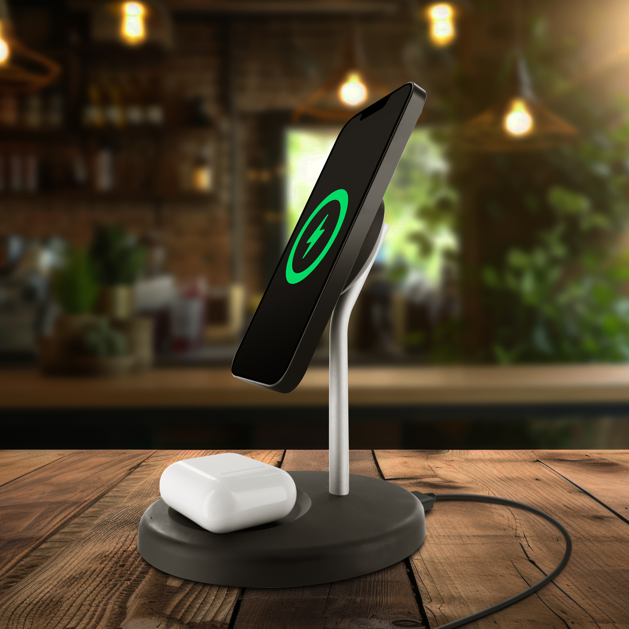 Un soporte de carga con un teléfono y AirPods sobre una mesa de madera en un café.