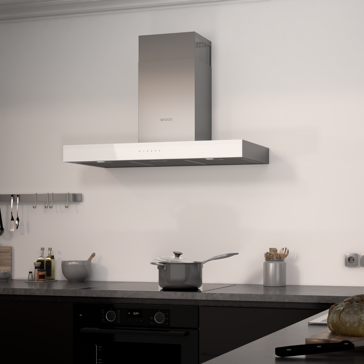 Hotte en acier inoxydable montée sur mur blanc, casserole sur la table de cuisson et pain sur le comptoir.