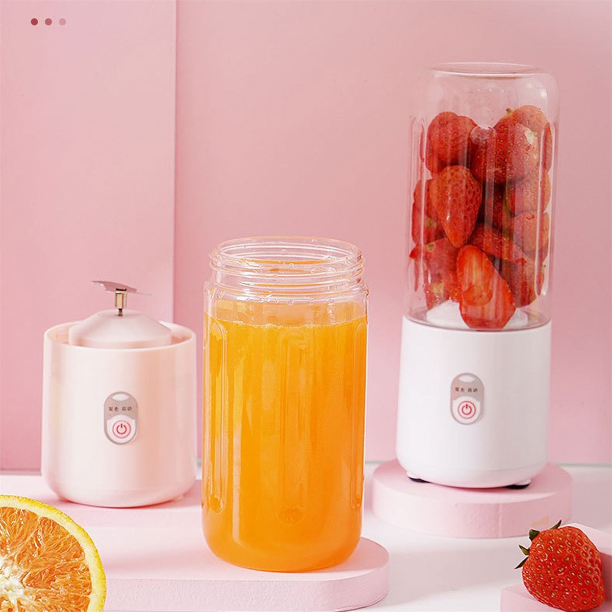 Drei Geräte: Saft in einem Glas, ein kleiner Mixer und ein Mixer mit Erdbeeren.