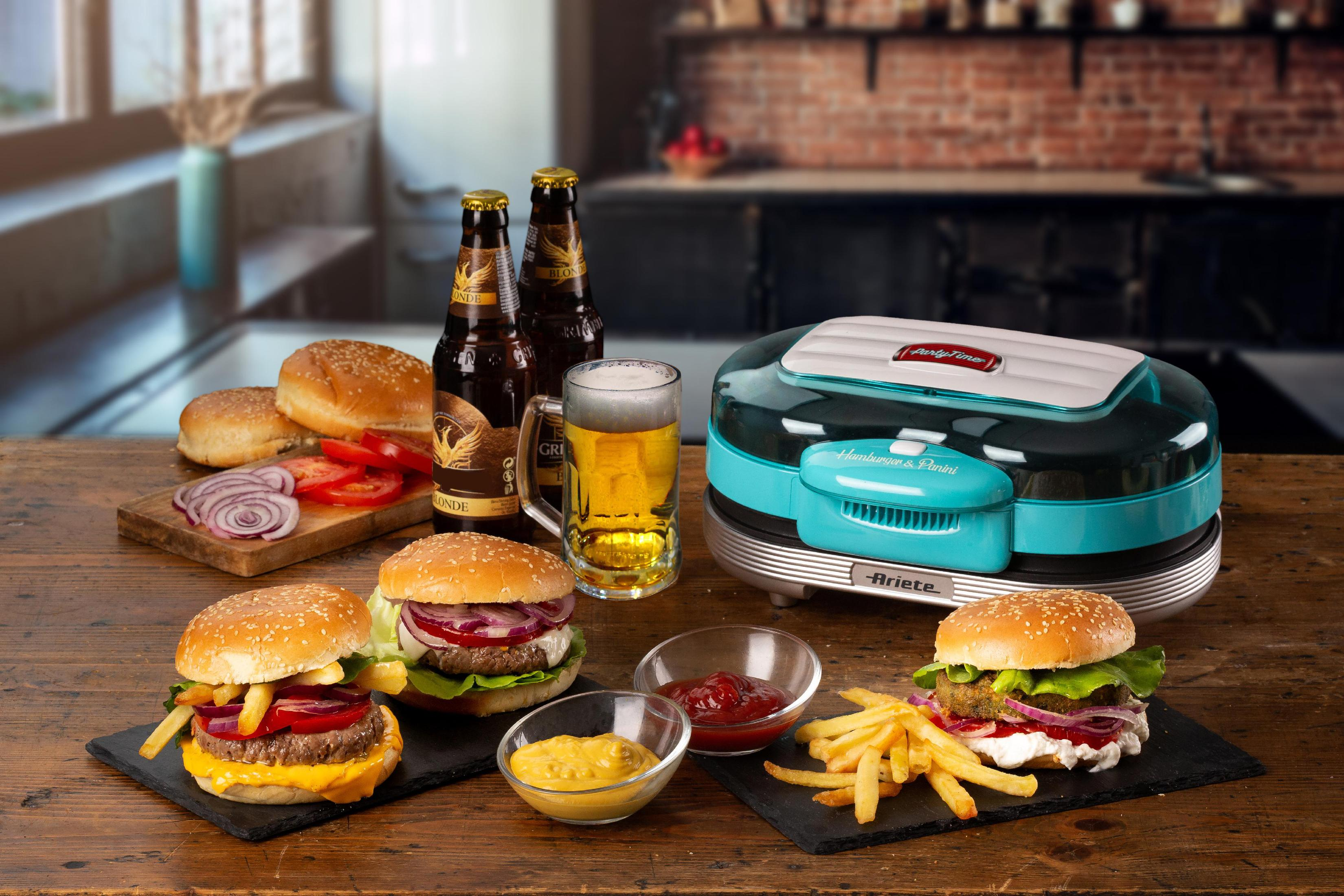 Burgers, friet, bier en een hamburgermachine op een houten tafel. Keukenachtergrond.