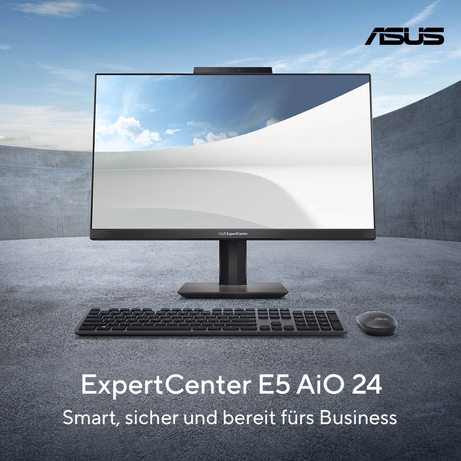 Computer ASUS all-in-one su scrivania con tastiera, mouse e cielo sullo sfondo.