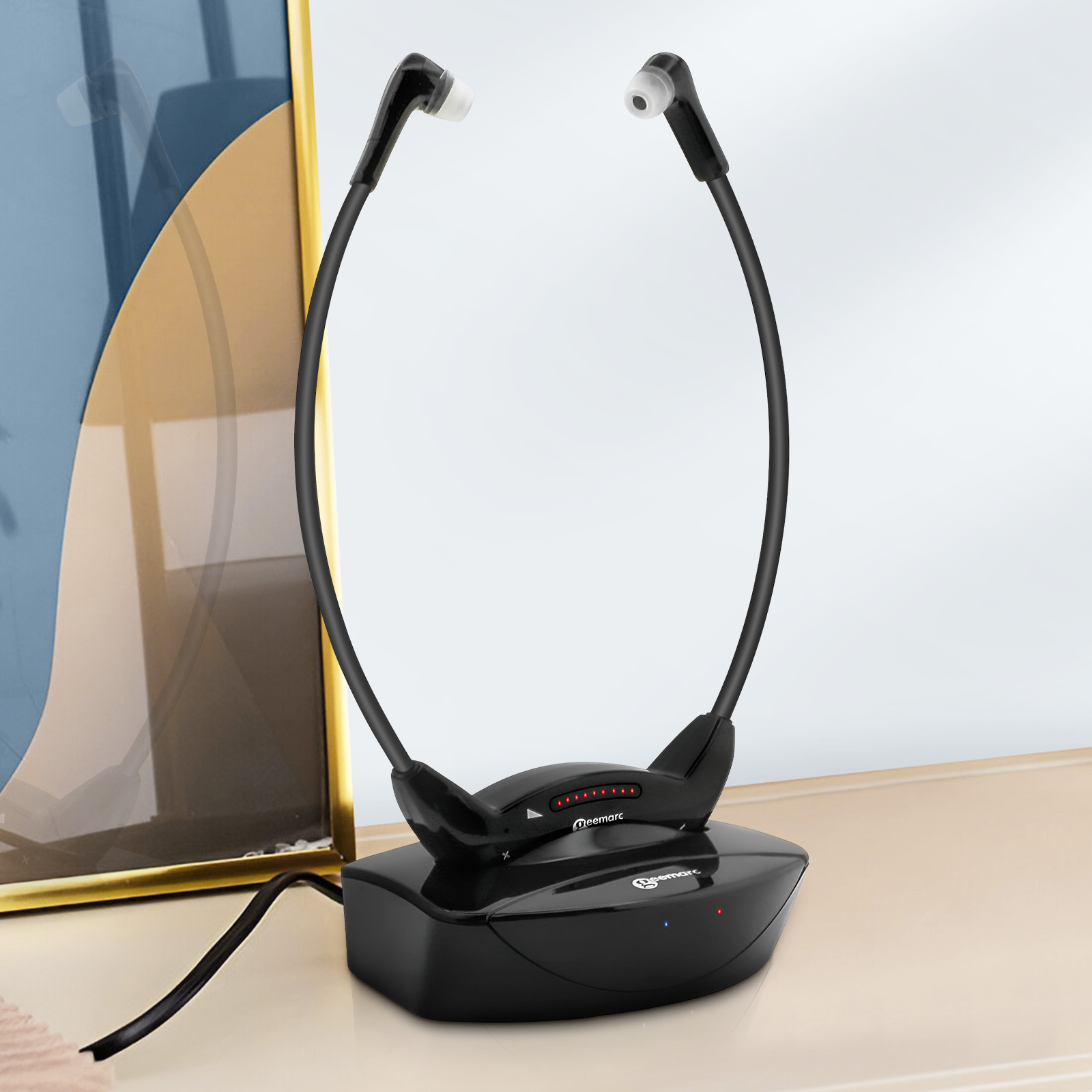 Schwarzes Hörgerät, das auf einer schwarzen Basis sitzt und mit einem Kabel verbunden ist. Im Hintergrund: Wand, Tisch.