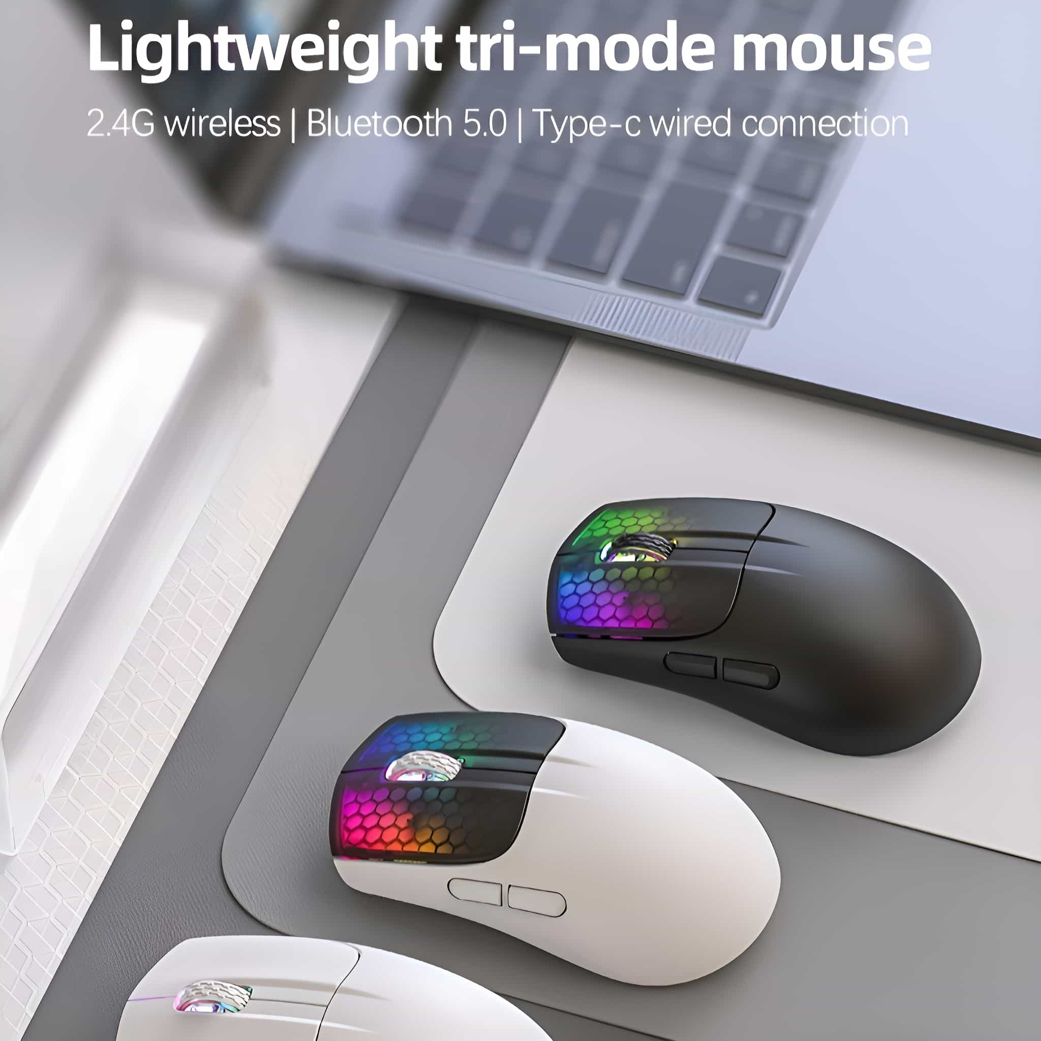 Drei kabellose Computer-Mäuse mit RGB-Beleuchtung auf einem Schreibtisch. Eine ist schwarz, zwei sind weiß, und ein Laptop ist im Hintergrund.