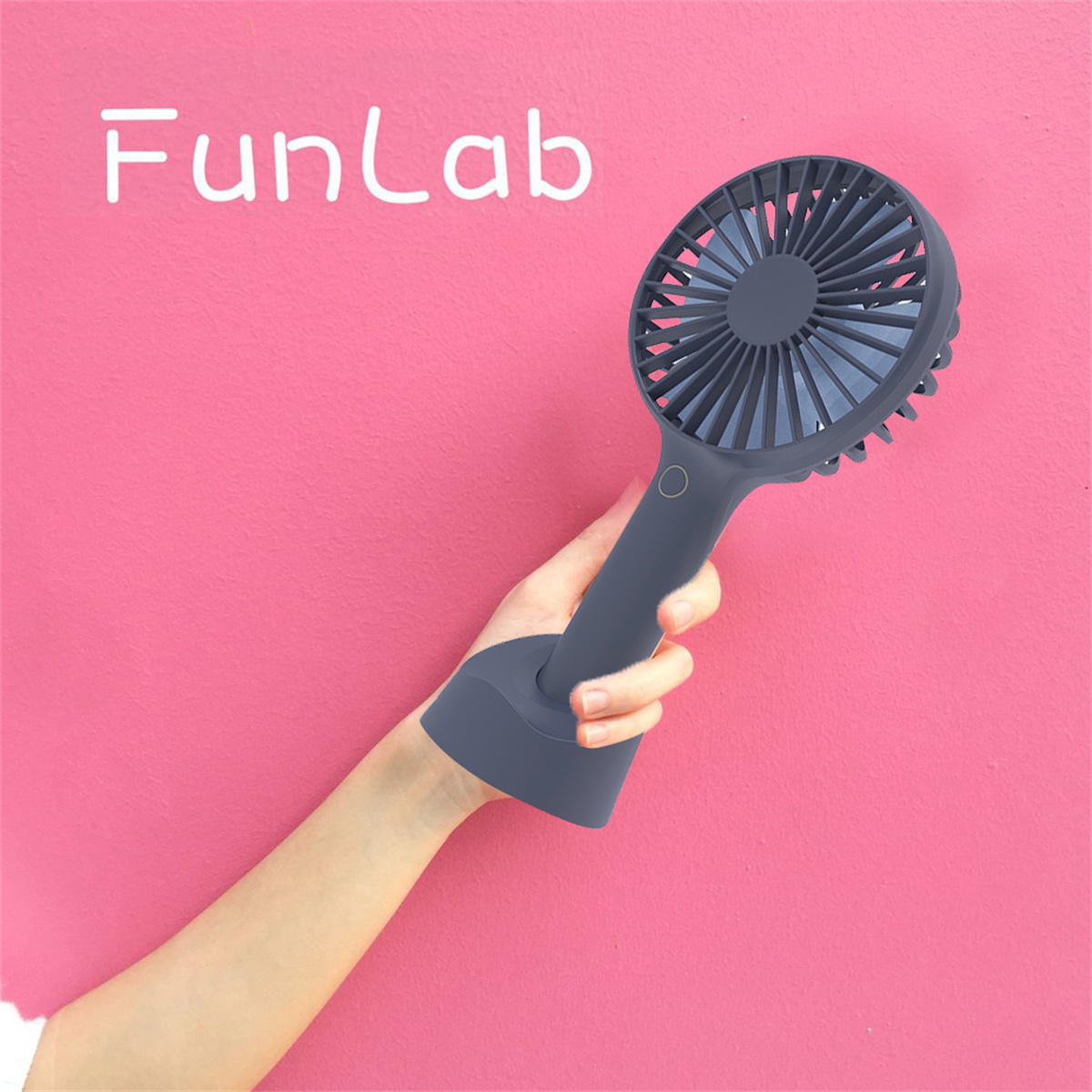 Ein Handventilator wird von einer Hand gehalten. Der Hintergrund ist rosa mit dem Logo FunLab.