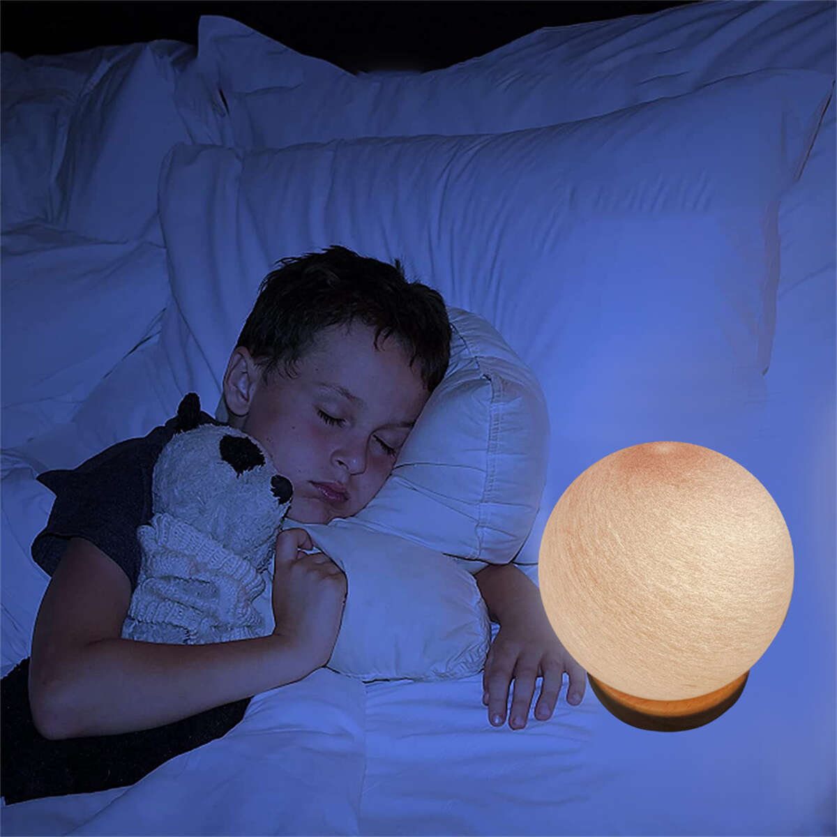 Ein schlafendes Kind mit einem Stofftier neben einer leuchtenden Kugel-Lampe. Der Raum ist dunkel.