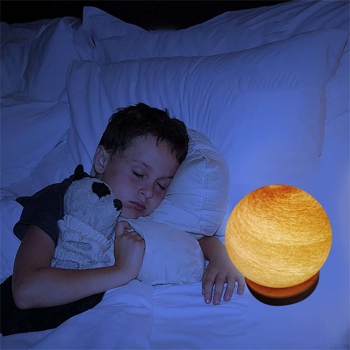 Ein schlafender Junge in einem Bett mit einer Mondlampe auf Holzsockel und einem Stofftier.