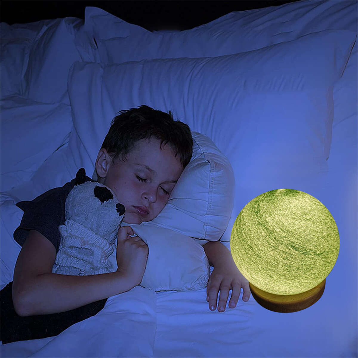 Ein Kind schläft im Bett mit einem Plüschtier und einem mondförmigen Nachtlicht.