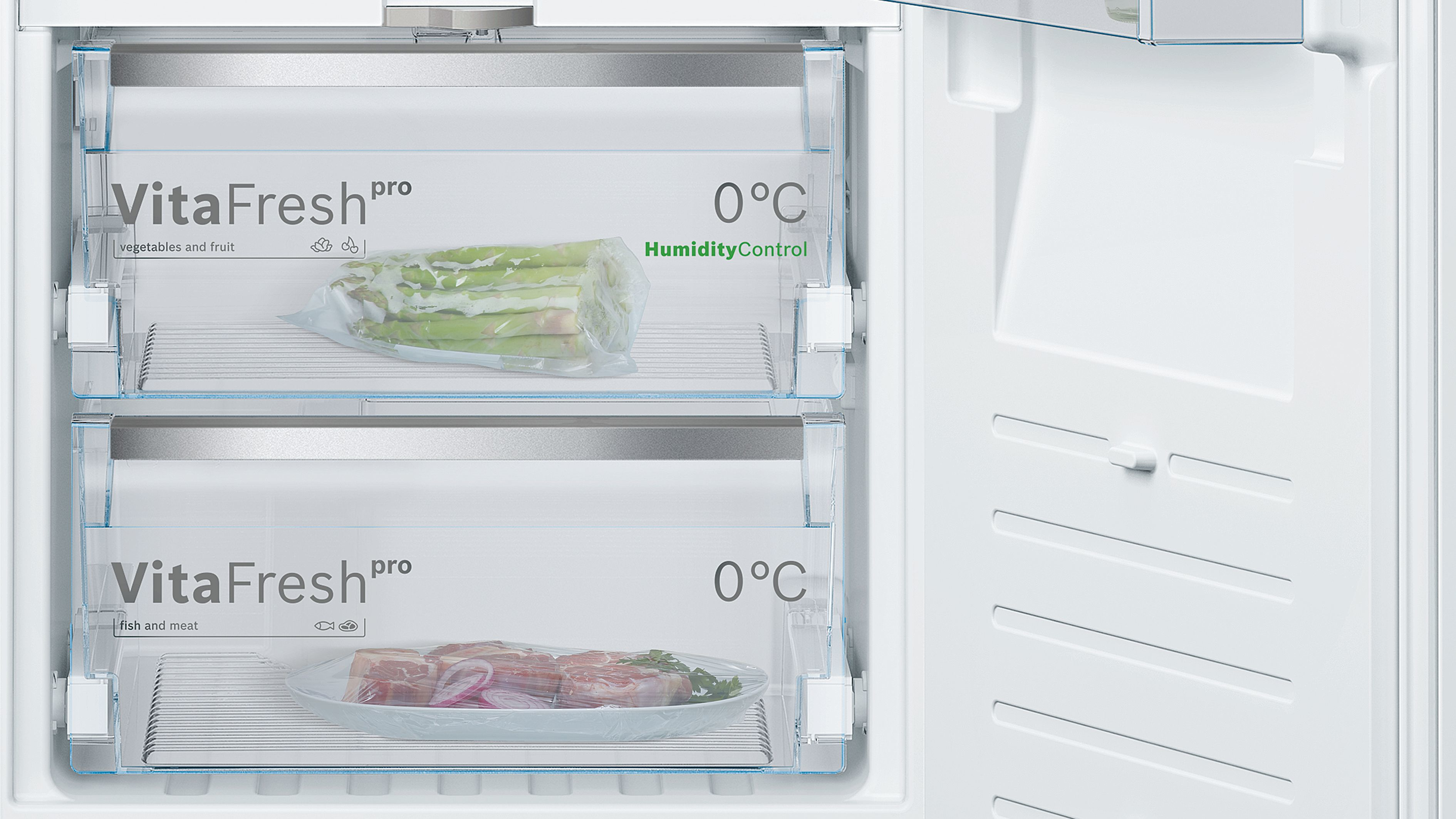 Kühlschrankinnenraum mit zwei Schubladen. Eine hat Spargel, die andere Fleisch, beschriftet VitaFresh pro, 0°C.