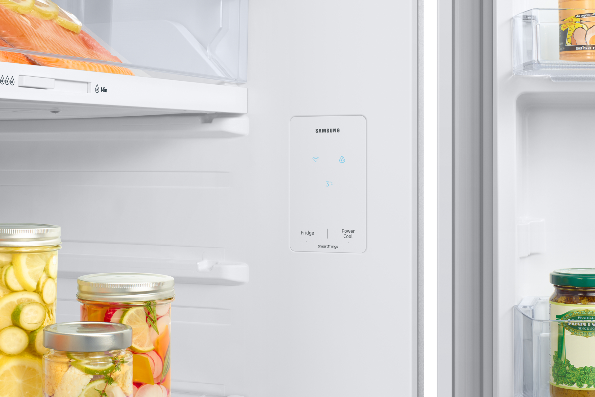Refrigerator interior with food jars and a control panel.