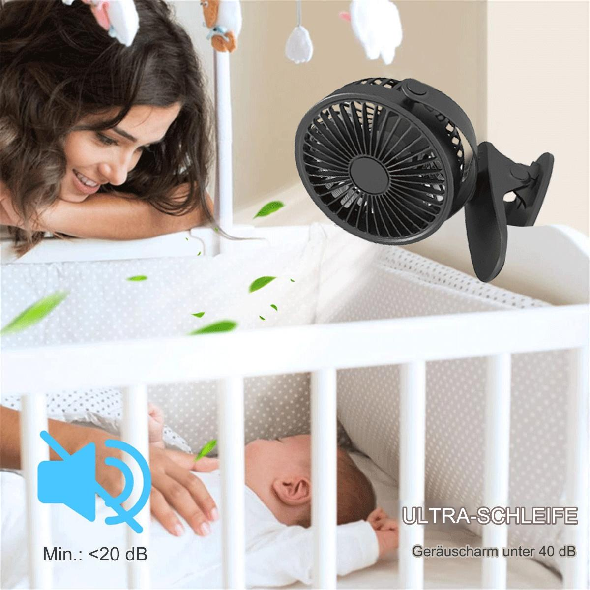 Ein Baby liegt in einem Kinderbett, eine Frau lächelt. Ein schwarzer Ventilator ist befestigt.